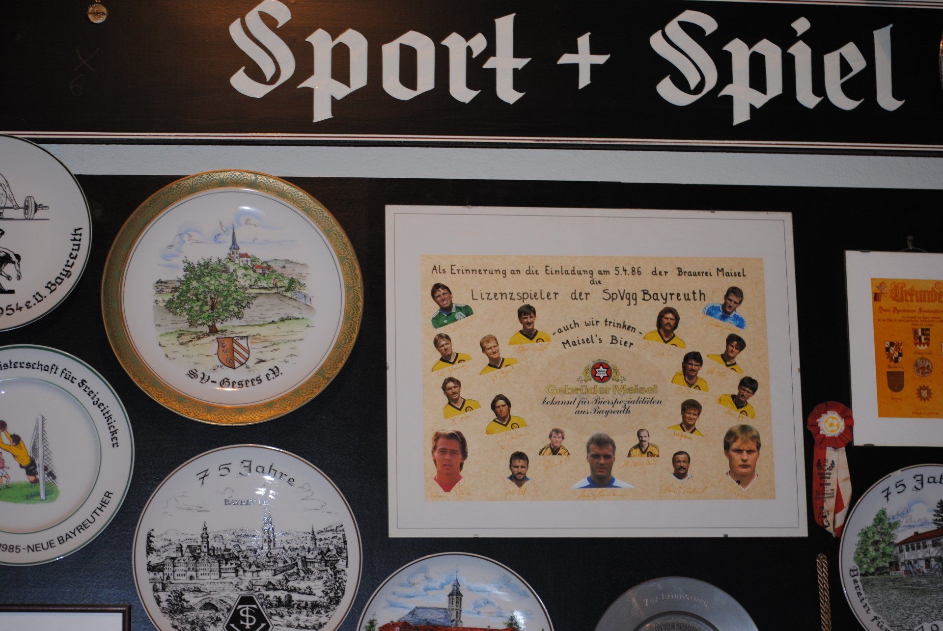 A display of plates under a sign that says sport + spiel