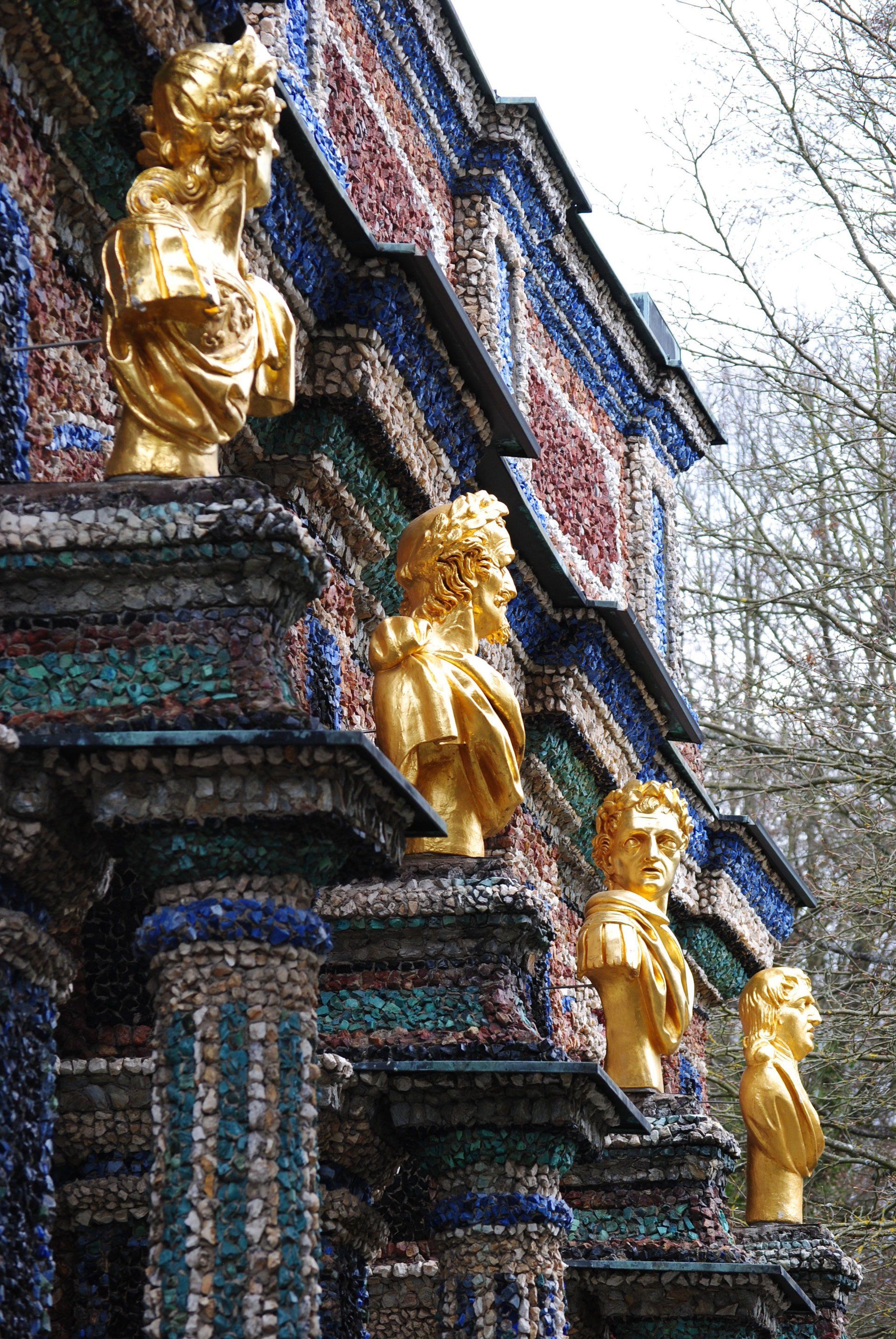 A row of gold statues on top of a building