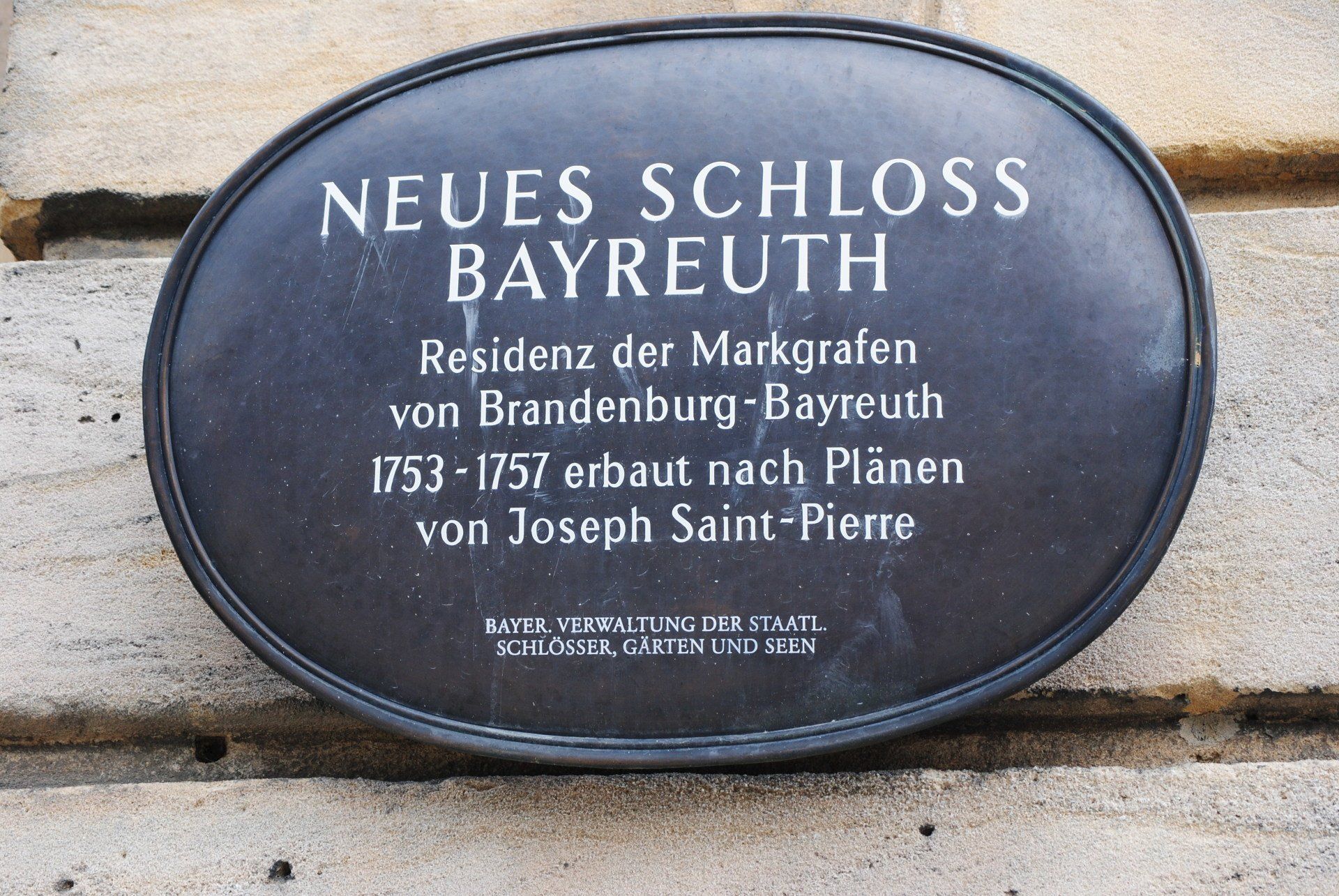 A sign on a wall that says neues schloss bayreuth