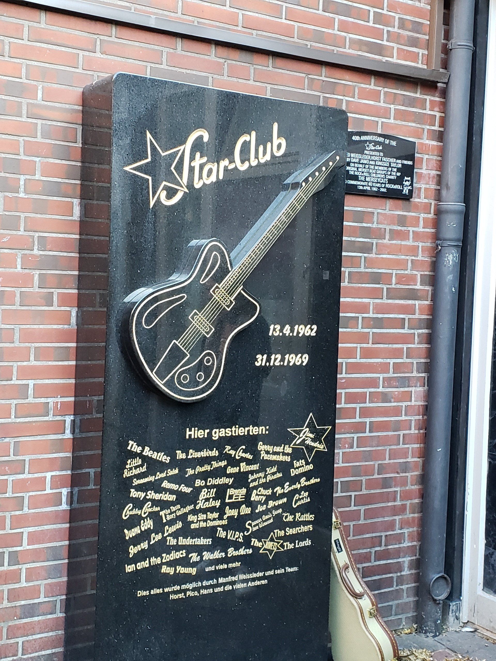 A black wall with a guitar on it that says star club