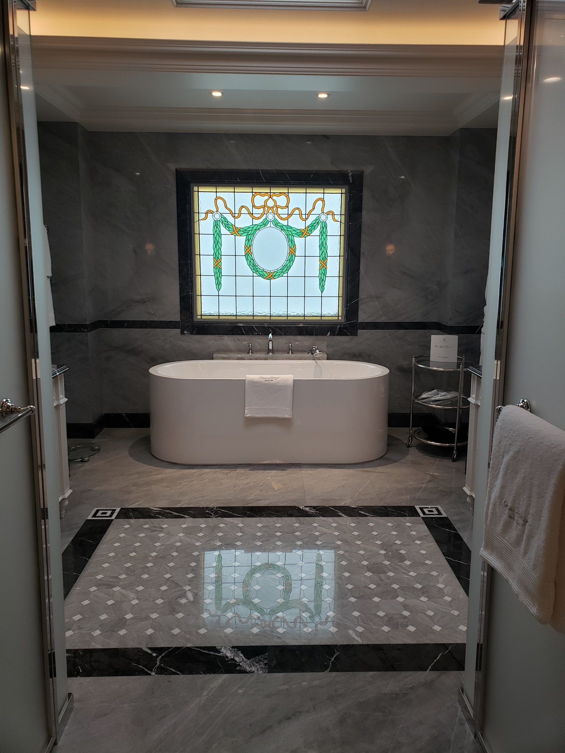 A bathroom with a bathtub and a stained glass window.