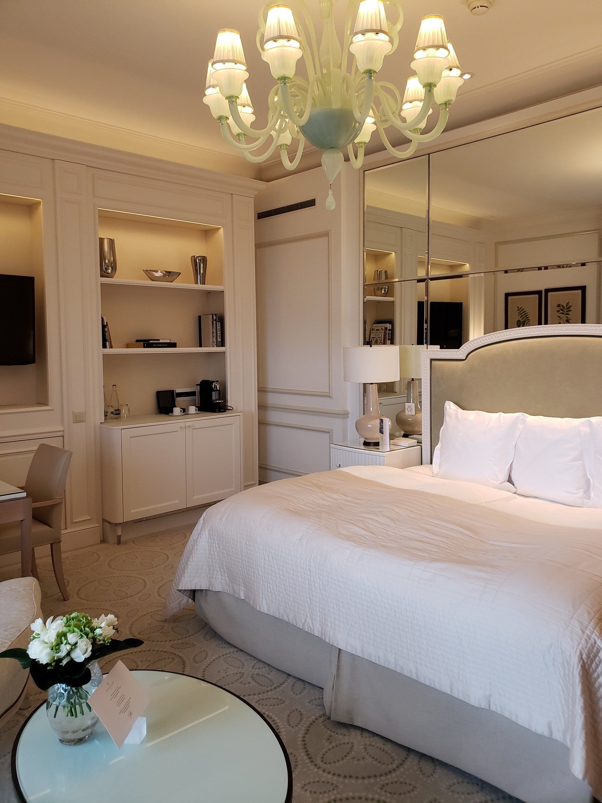 A hotel room with a large bed and a chandelier