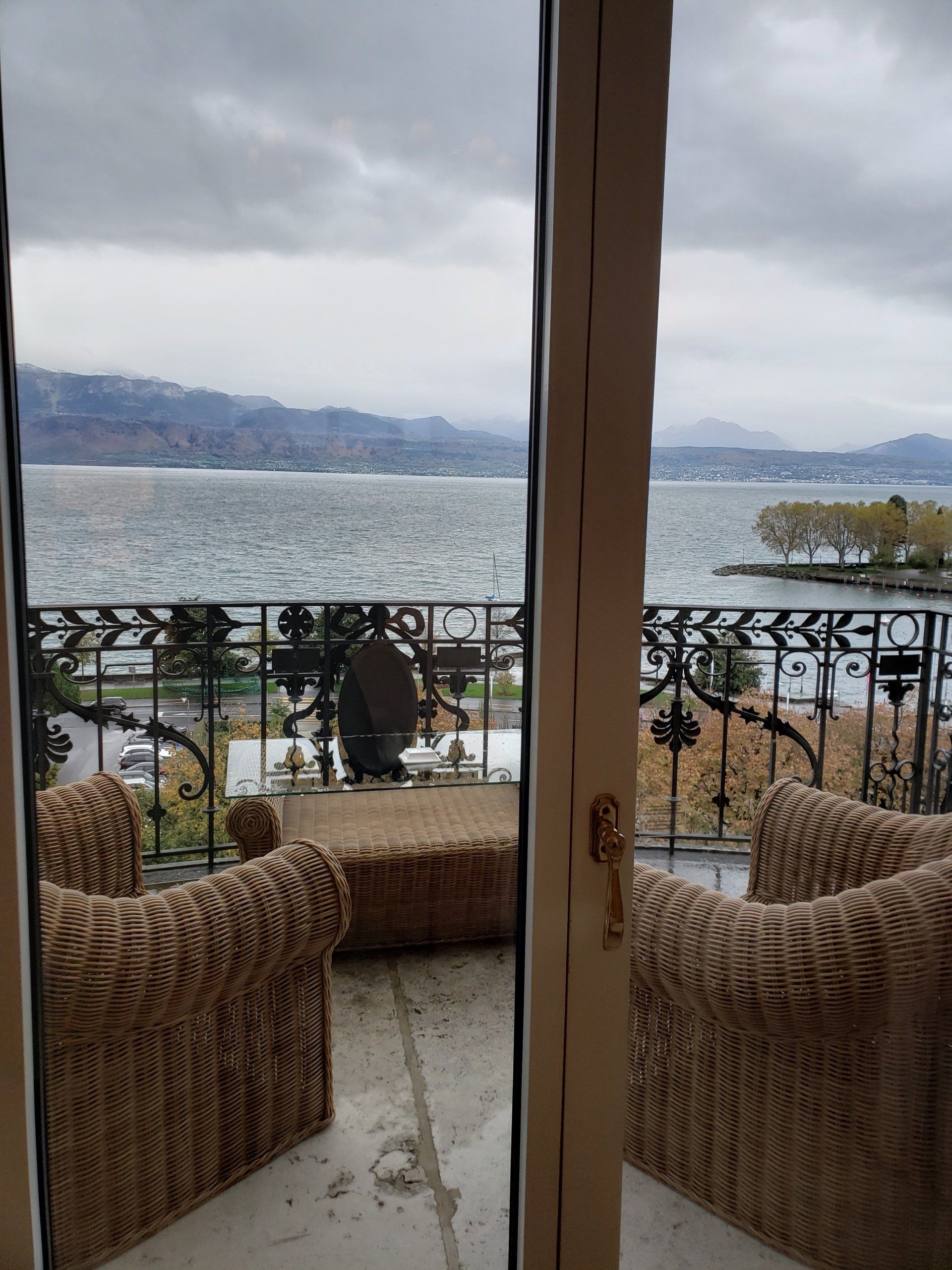 A balcony with wicker chairs and a view of the water