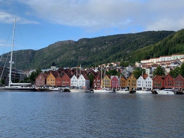 A row of colorful houses sit next to a body of water.