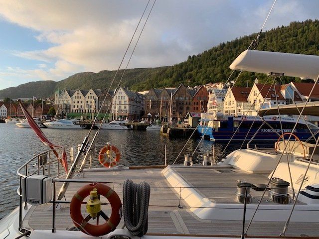 A boat is docked in a harbor with a life preserver on the deck.