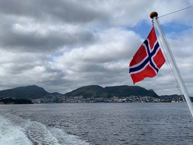 A red white and blue flag is flying over a body of water