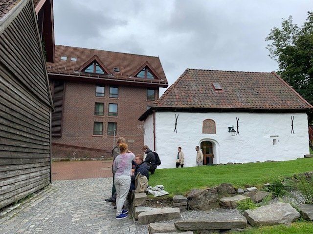 A group of people are standing in front of a white building.
