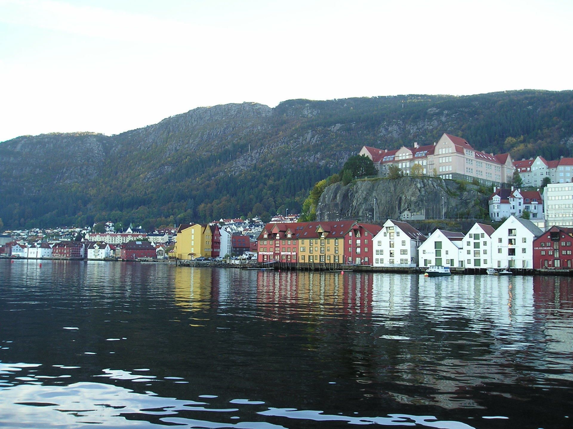 A large body of water surrounded by buildings and mountains
