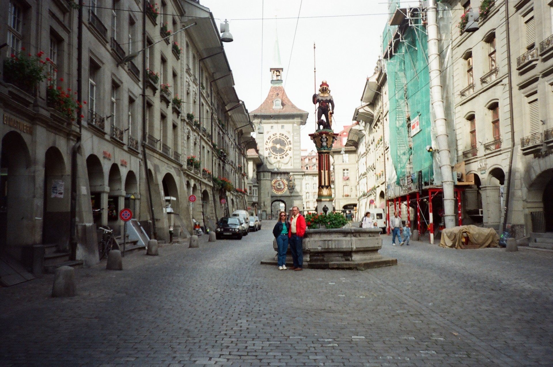 A couple standing in front of a fountain in a city
