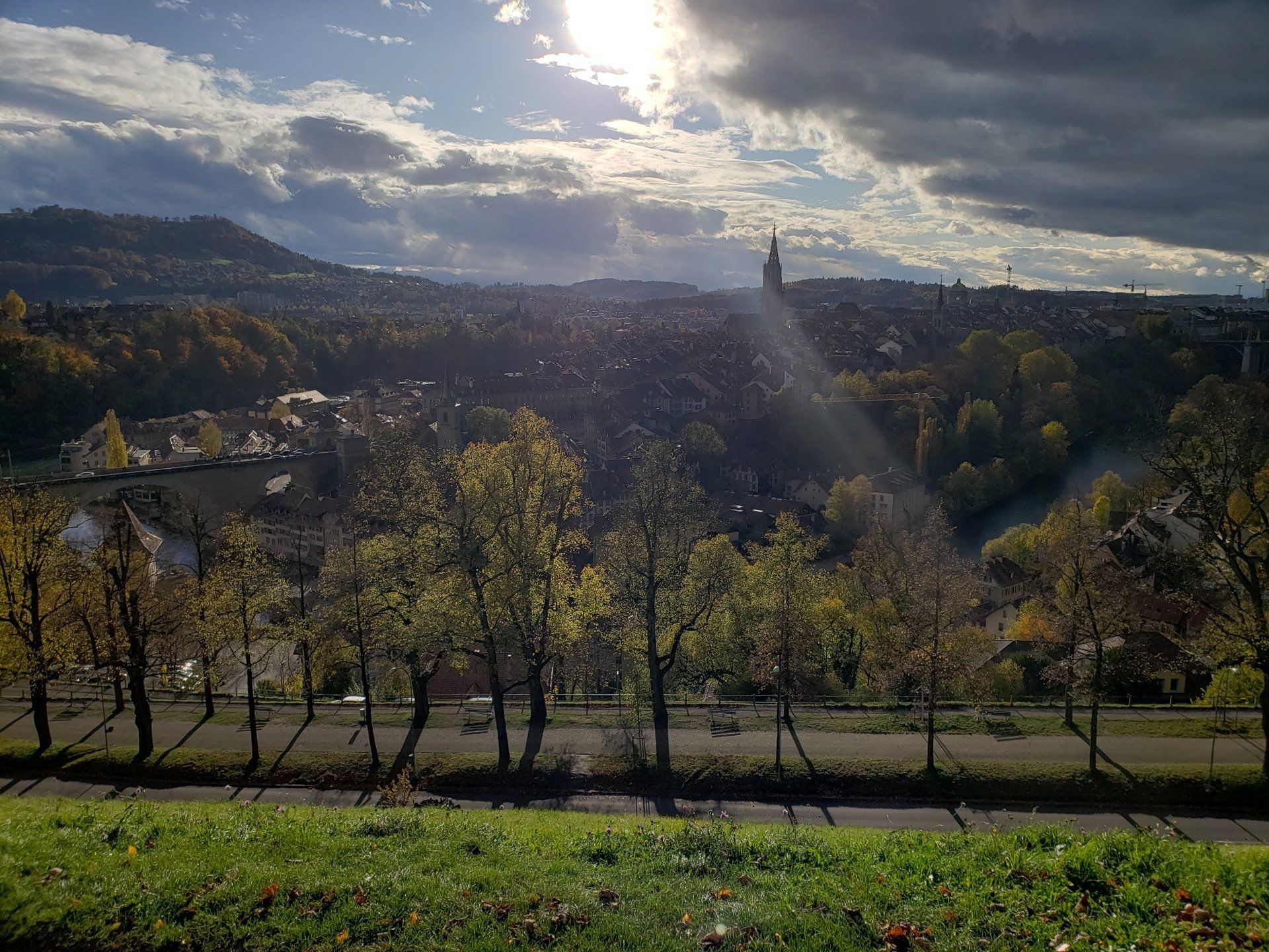 The sun is shining through the clouds over a city.