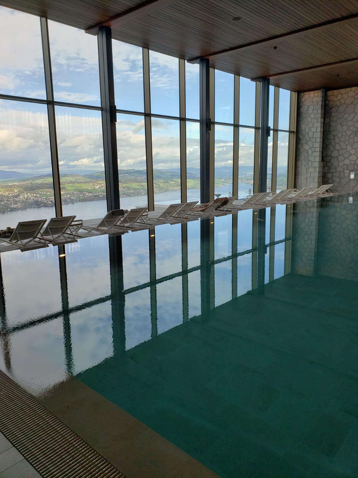 A large indoor swimming pool with a view of a body of water.