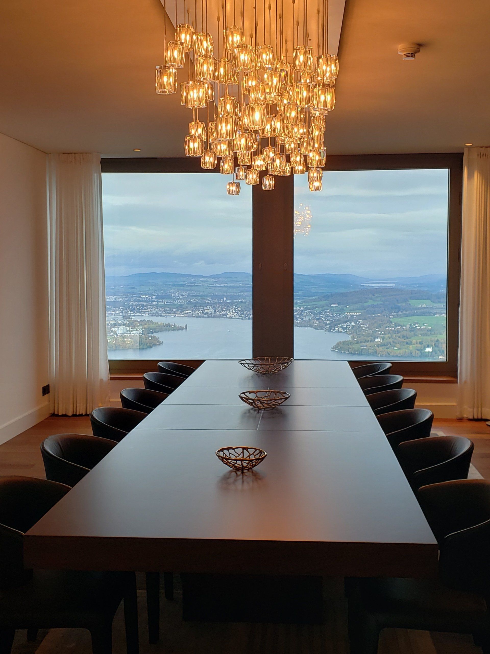 A long table and chairs in a room with a large window