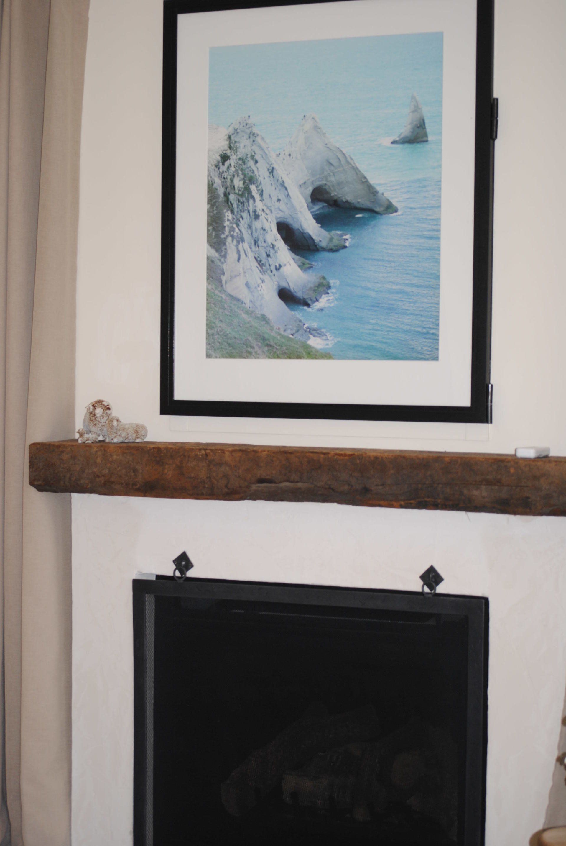A fireplace with a picture on the wall above it