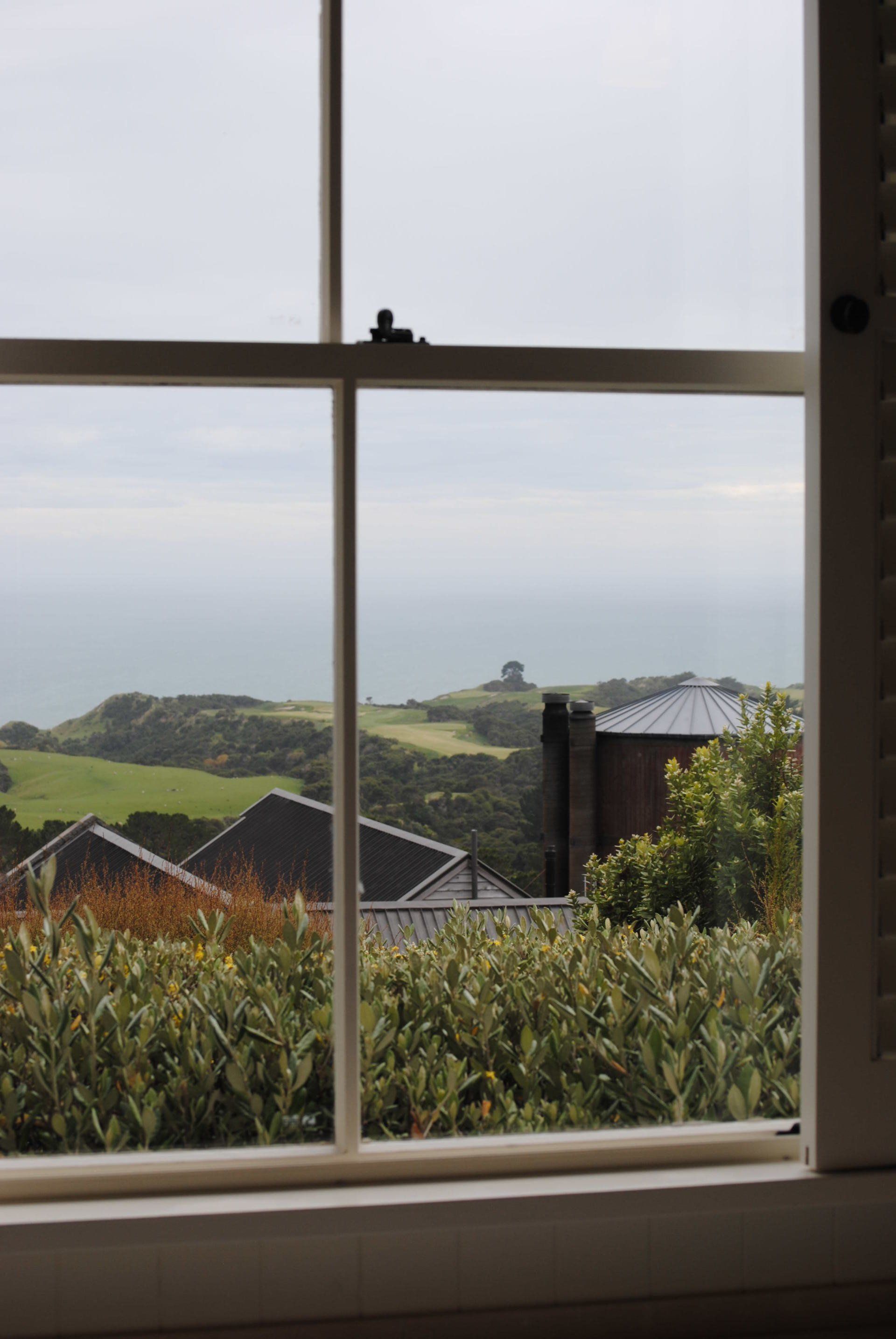 A window with a view of a field and houses