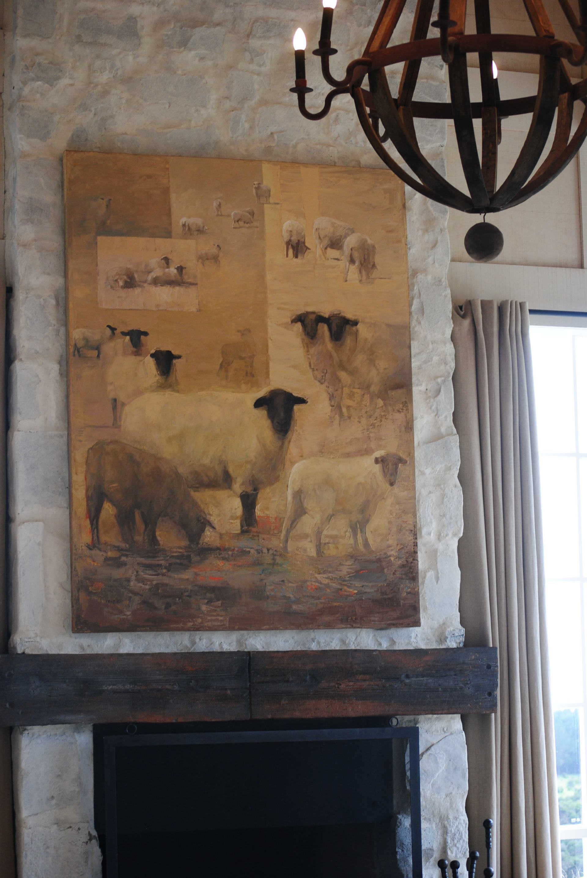 A painting of sheep on a wall above a fireplace