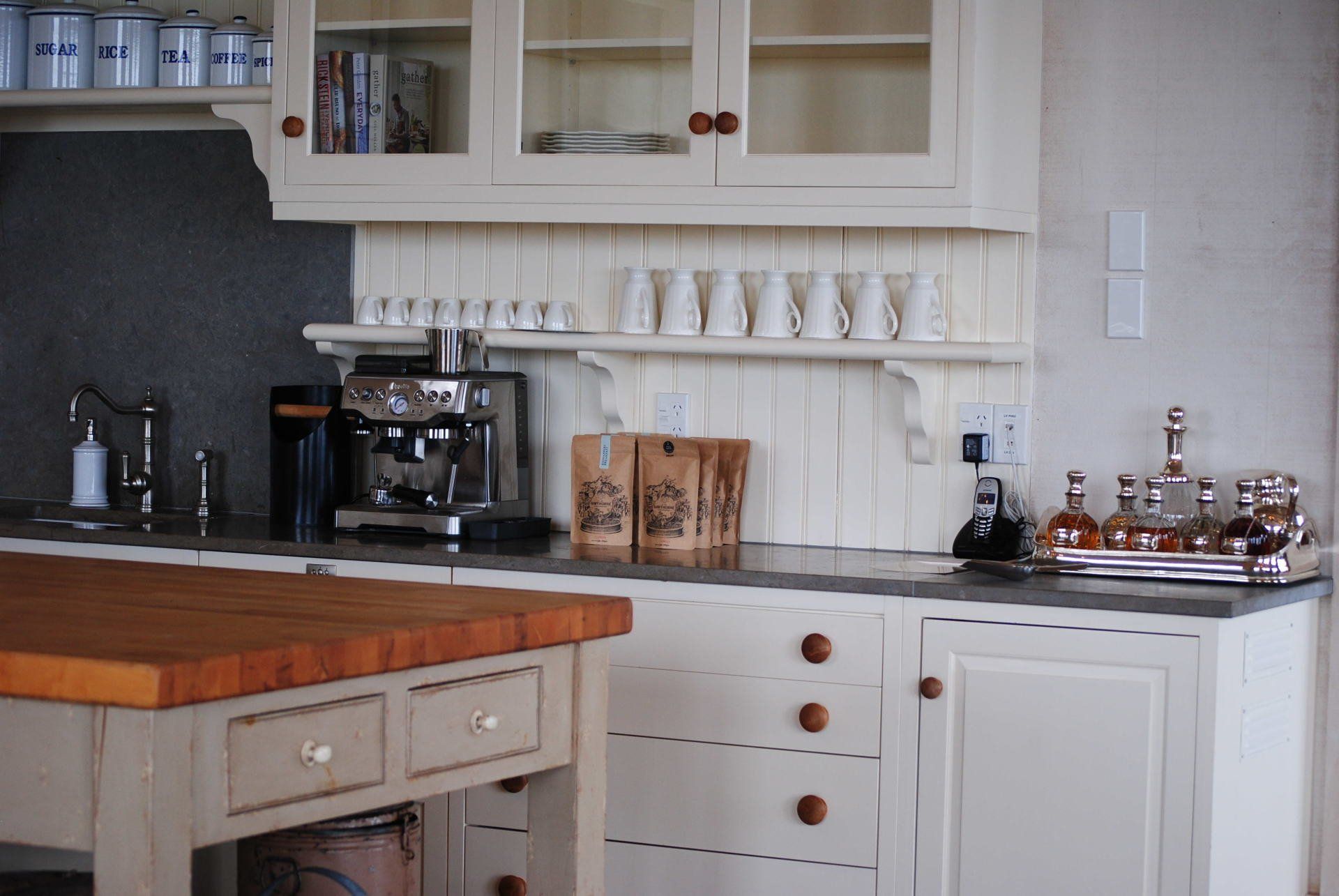 A kitchen with white cabinets and a wooden table