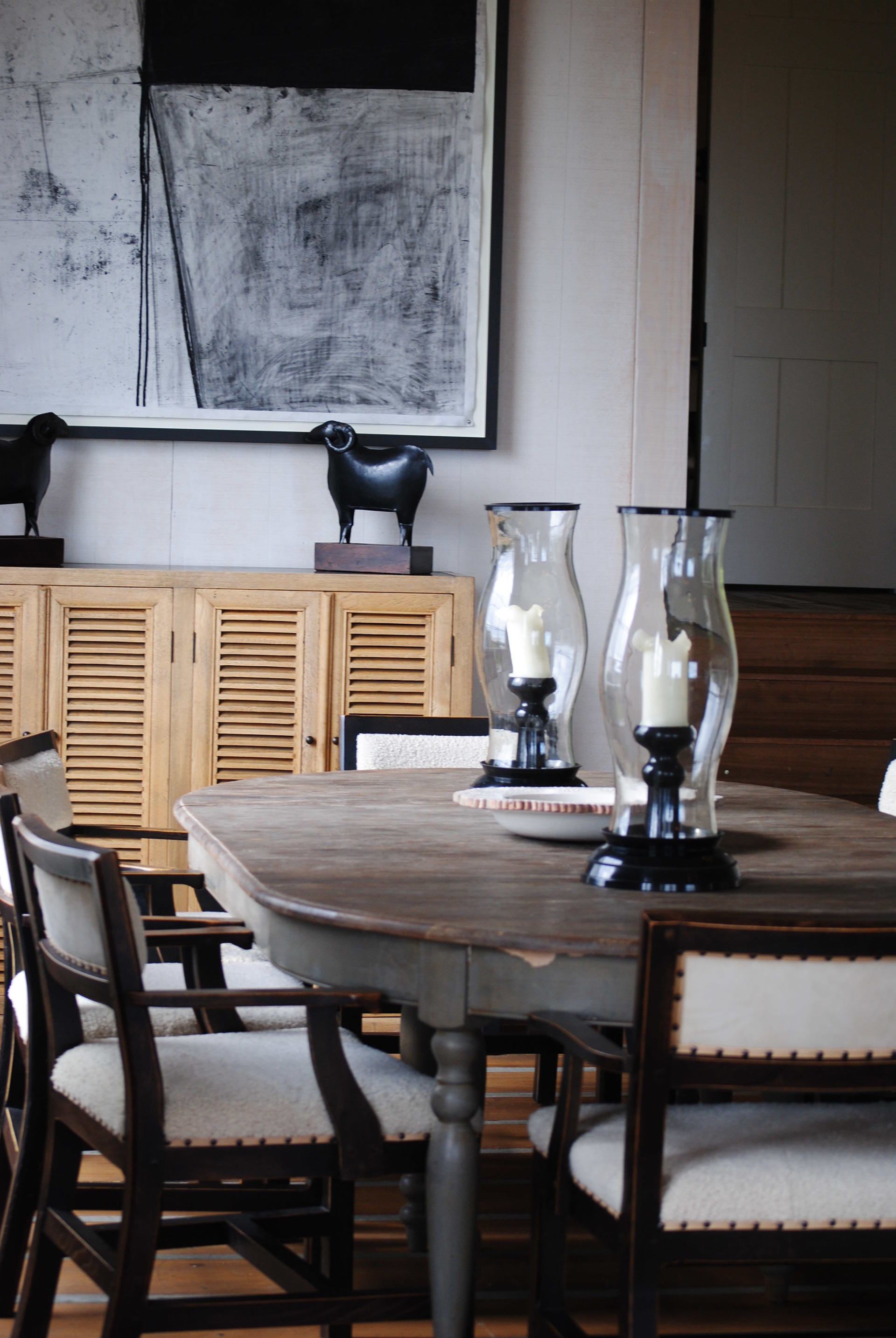 A dining room table with chairs and candles on it