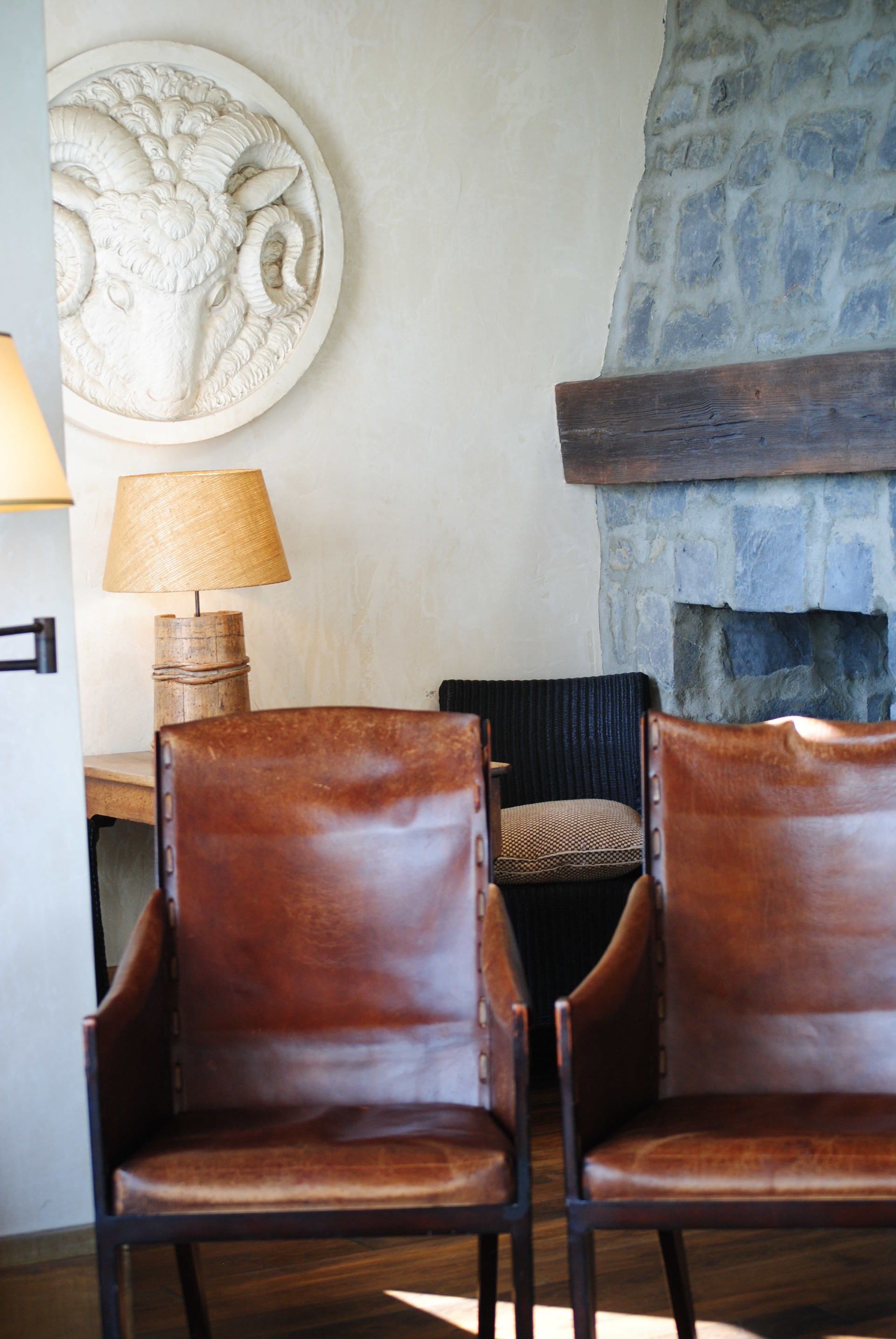 Two brown leather chairs are sitting in front of a fireplace.