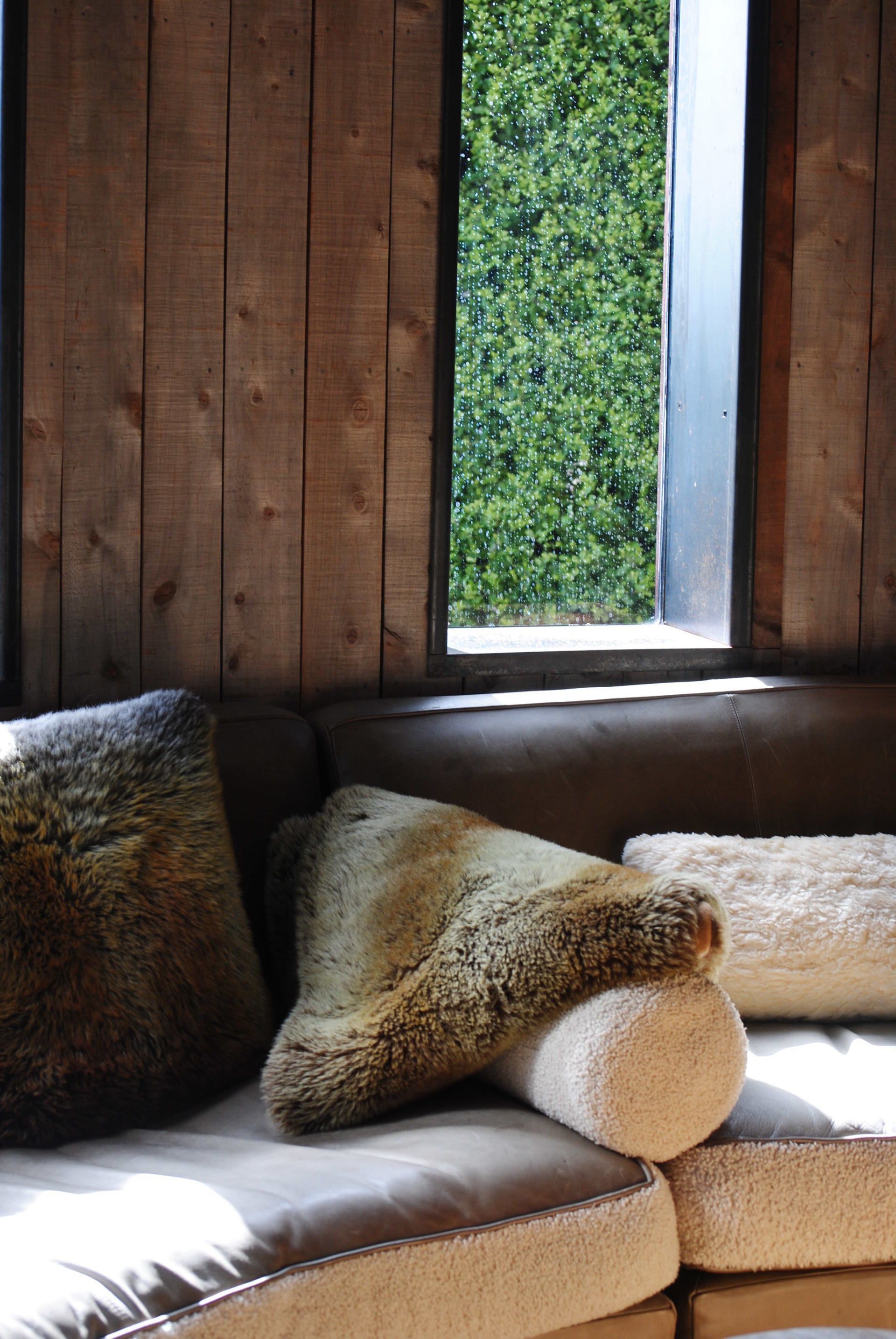 A couch with pillows on it in front of a window