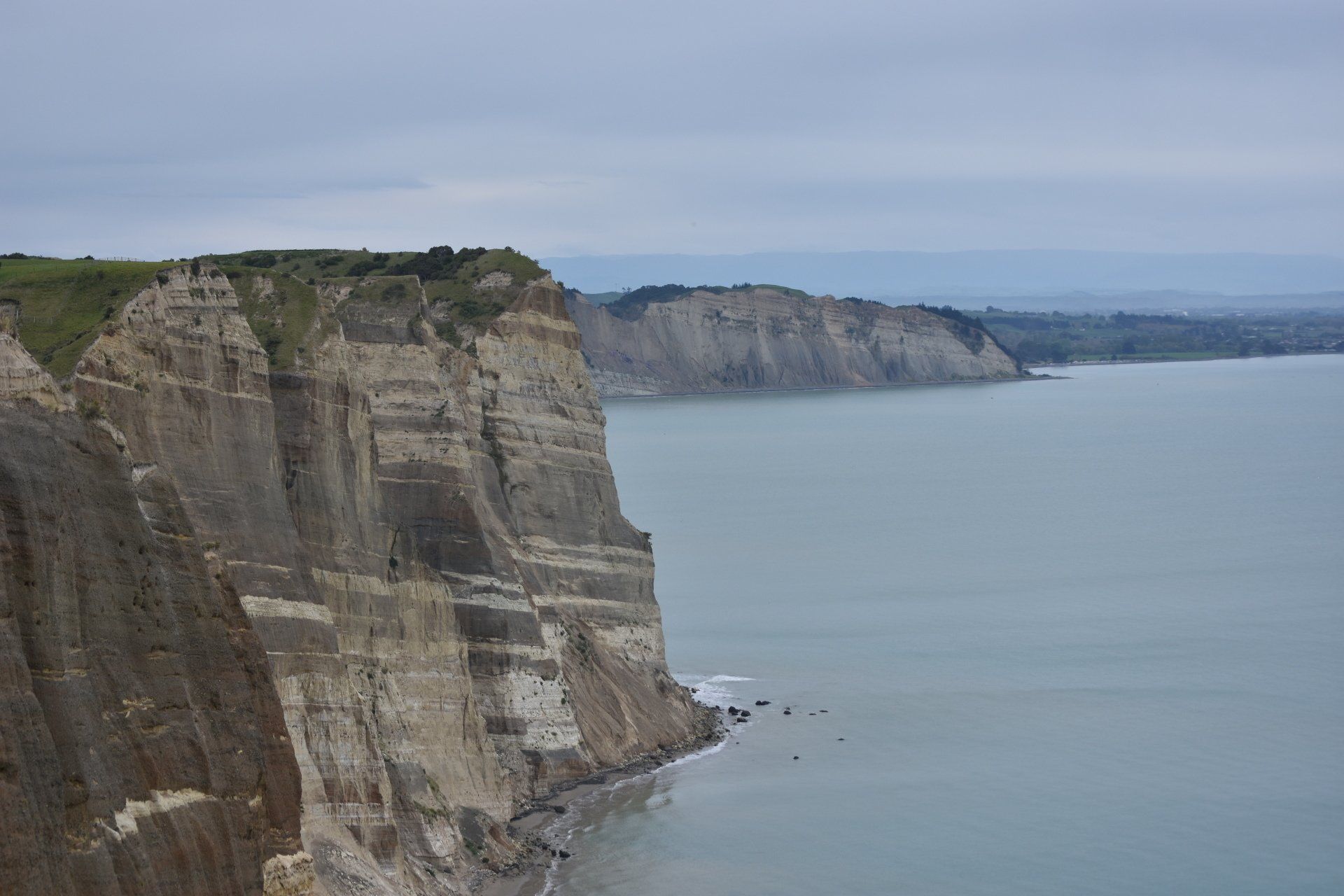 A view of a cliff overlooking a body of water.