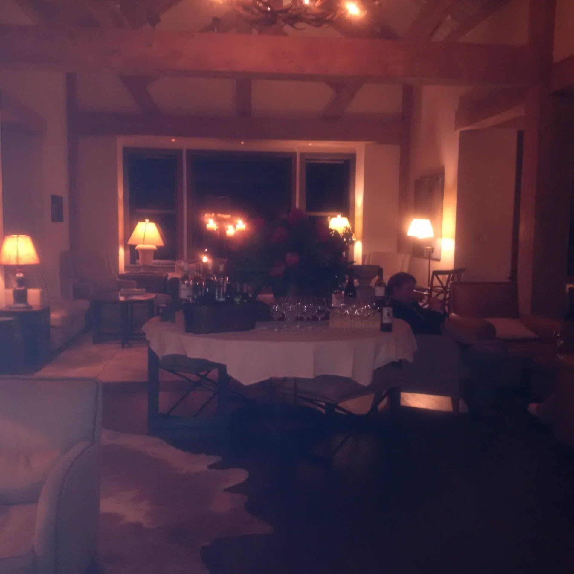 A dark living room with a table and chairs