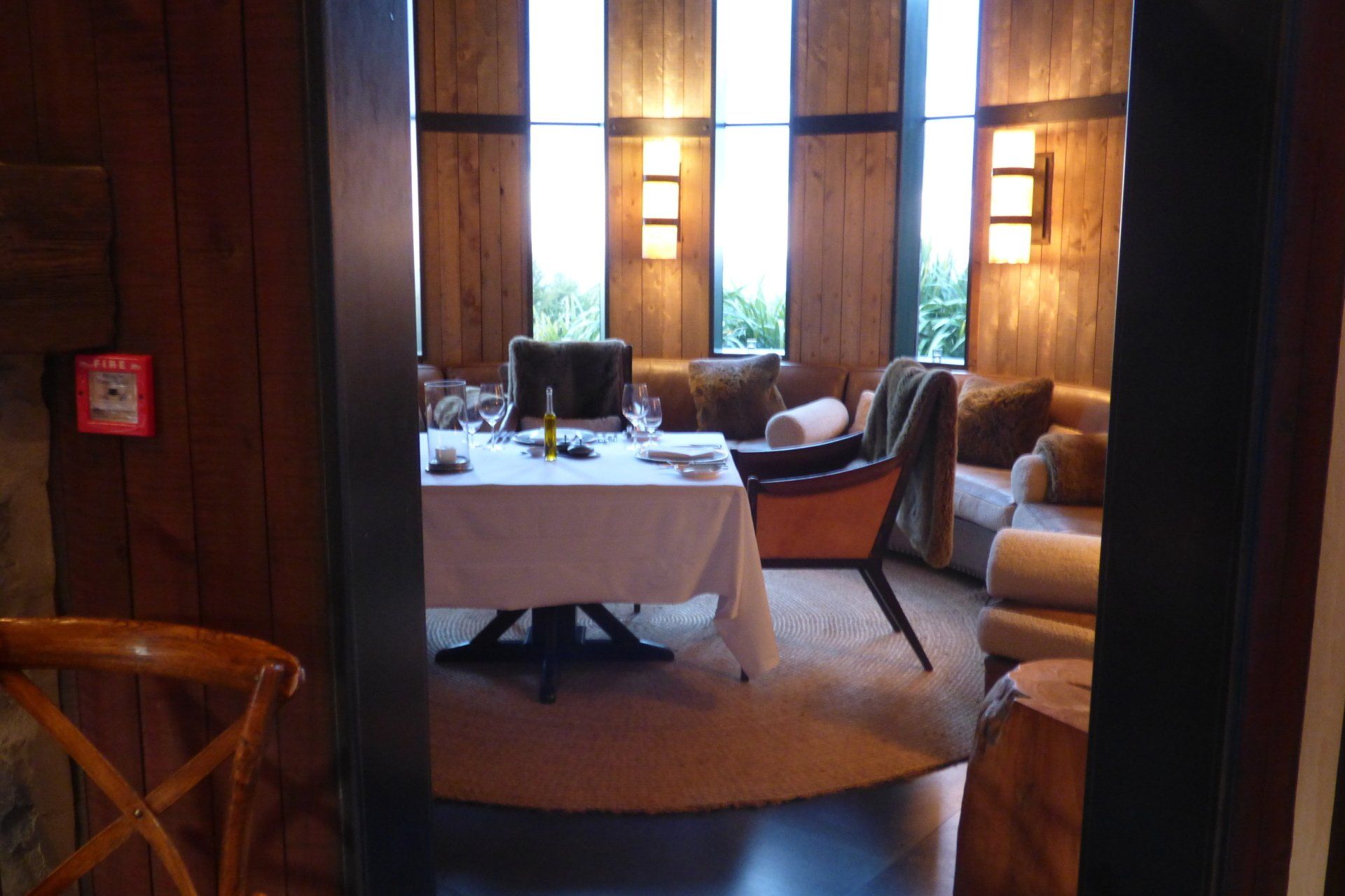 A room with a table and chairs and a fire alarm on the wall