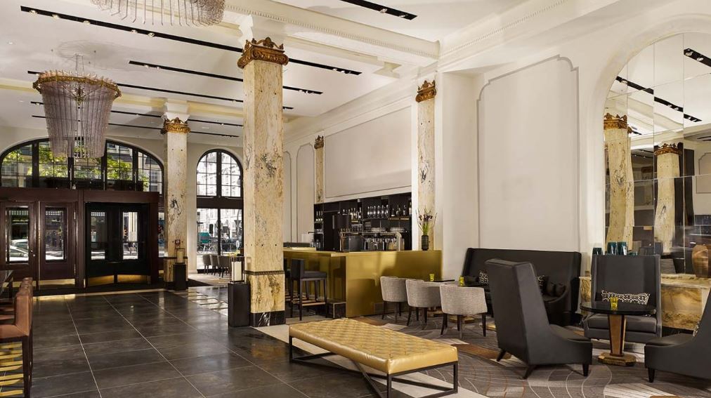 A large lobby with a lot of furniture and a chandelier hanging from the ceiling.