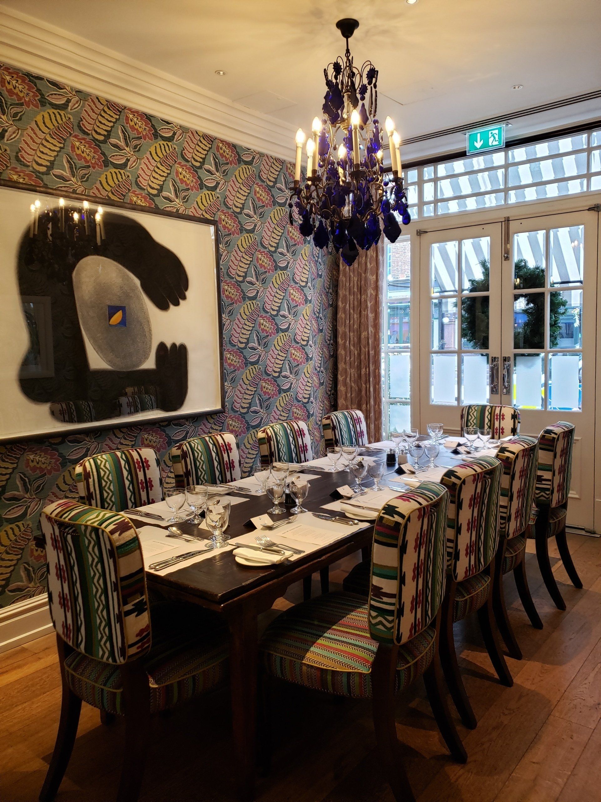 A dining room with a long table and chairs and a chandelier