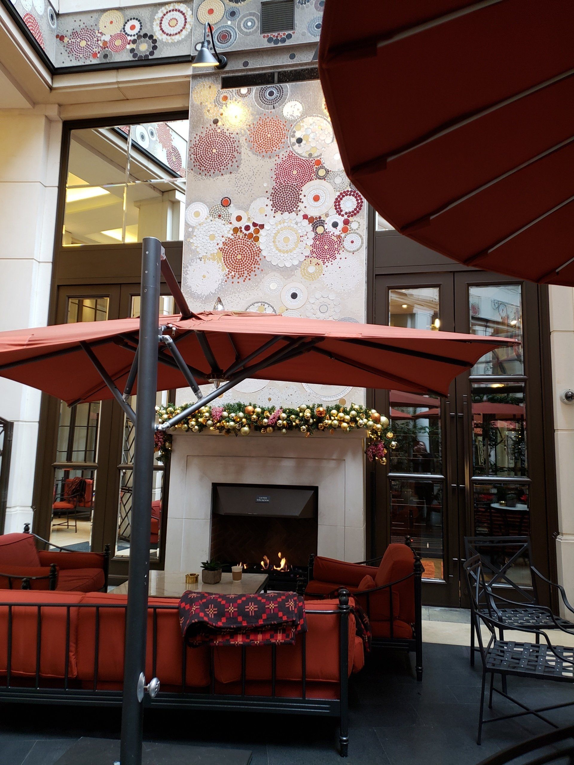 A patio area with a fireplace and umbrellas