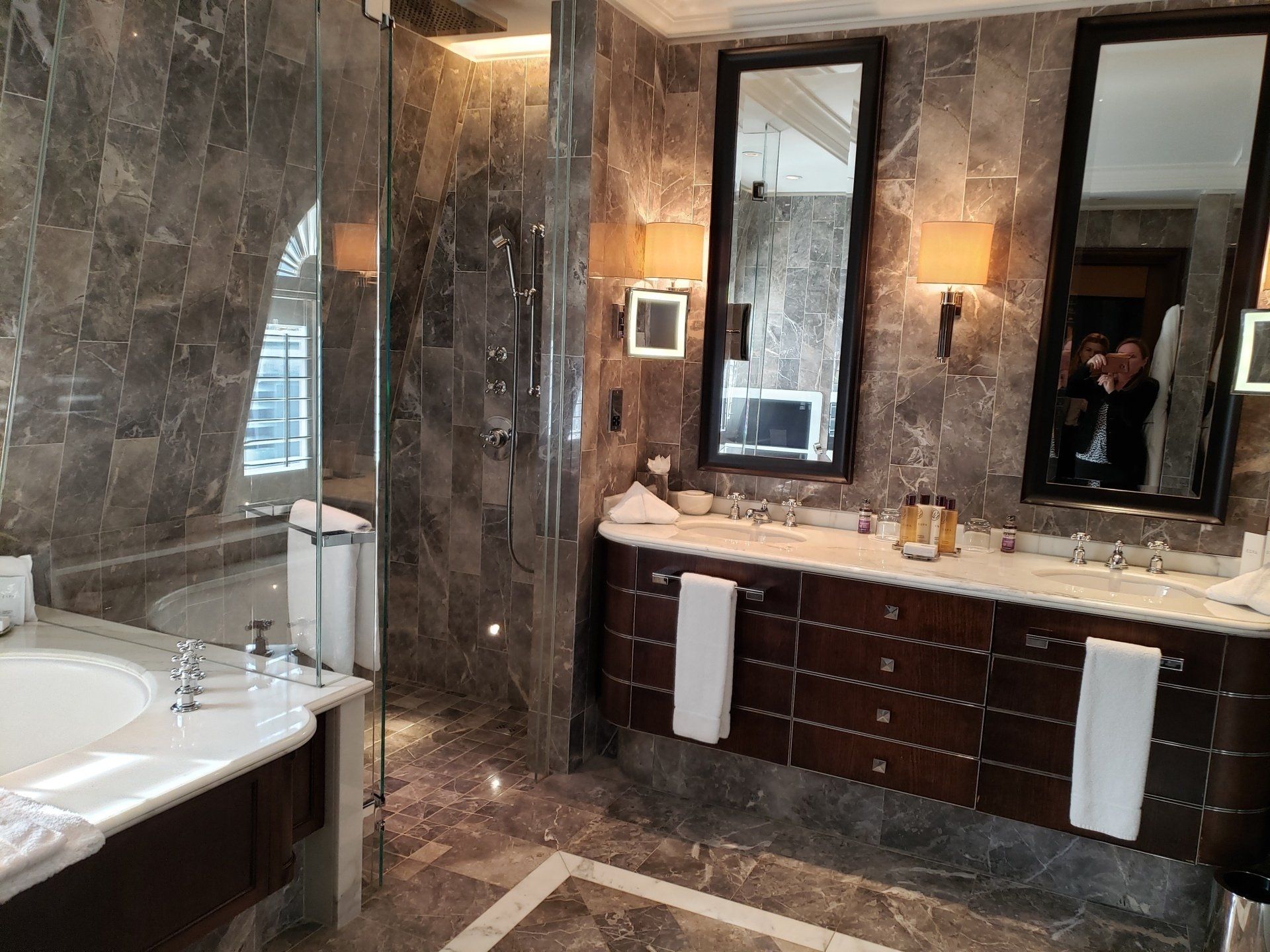 A bathroom with two sinks , a tub and a shower.