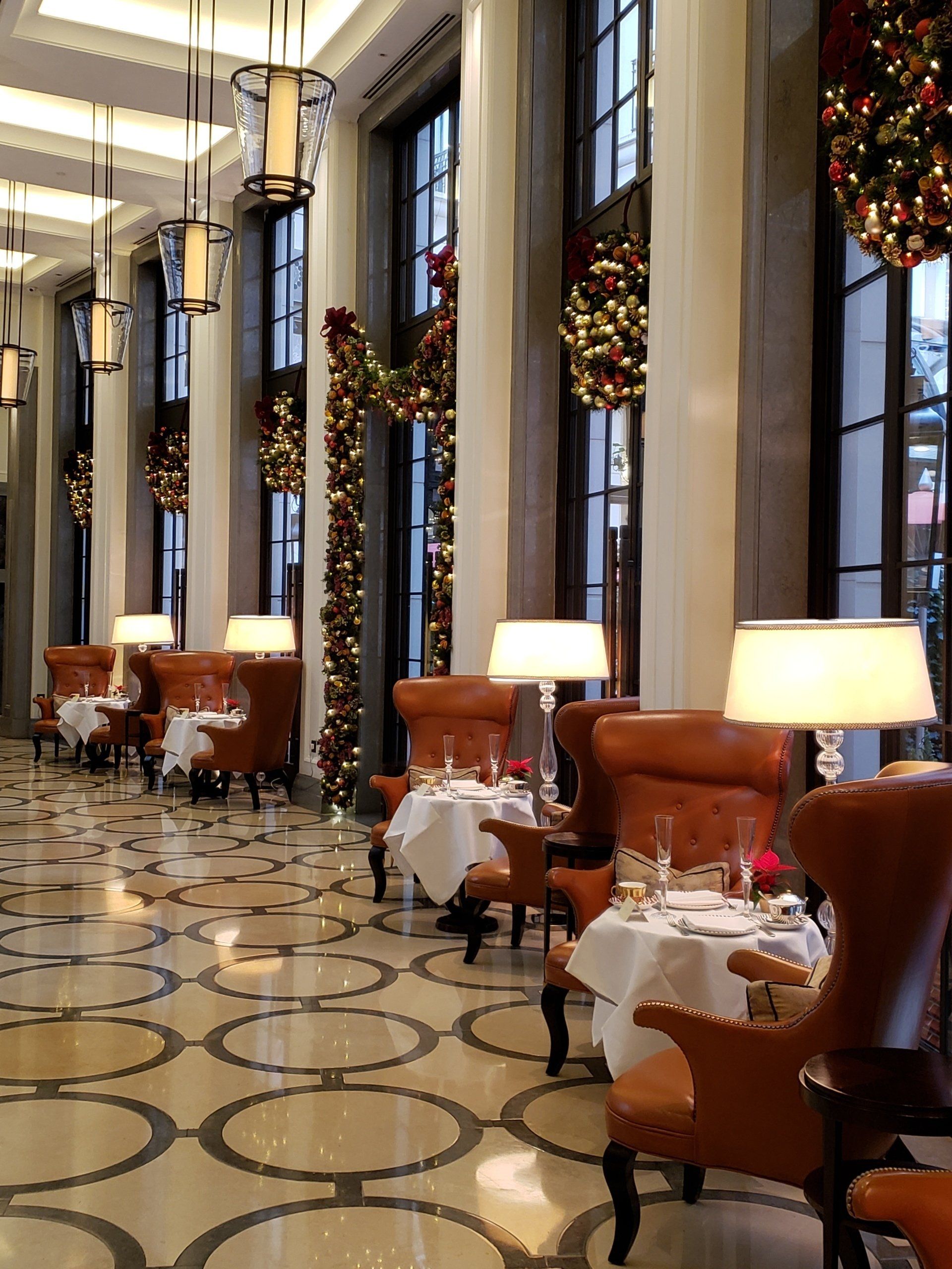 A long hallway with tables and chairs and christmas decorations