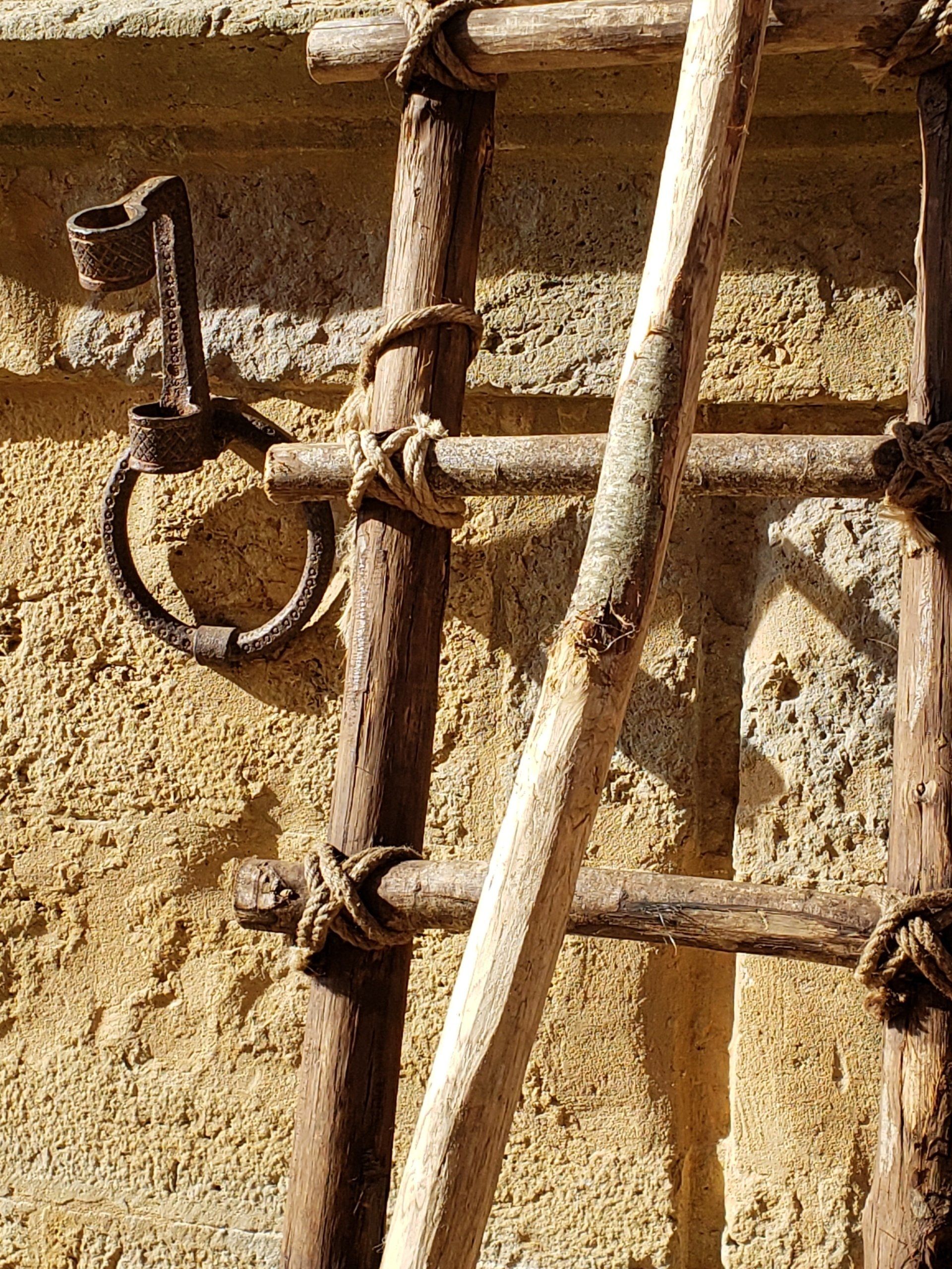 A close up of a wooden ladder against a wall