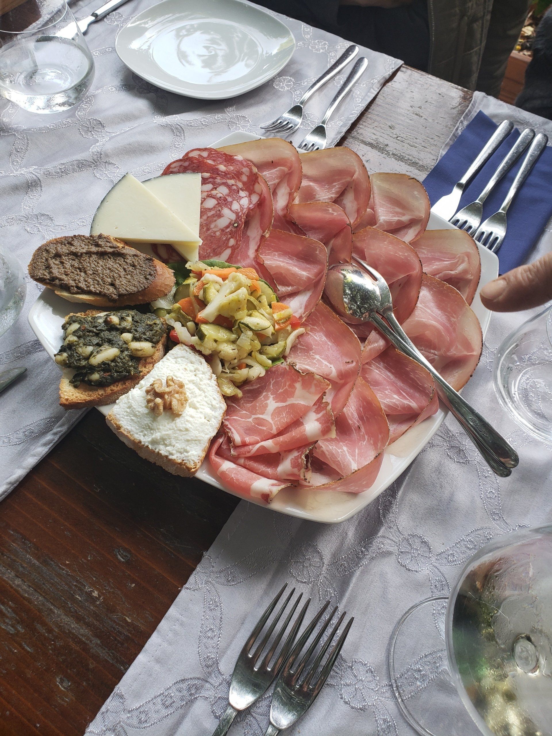 A plate of food on a table with forks and spoons