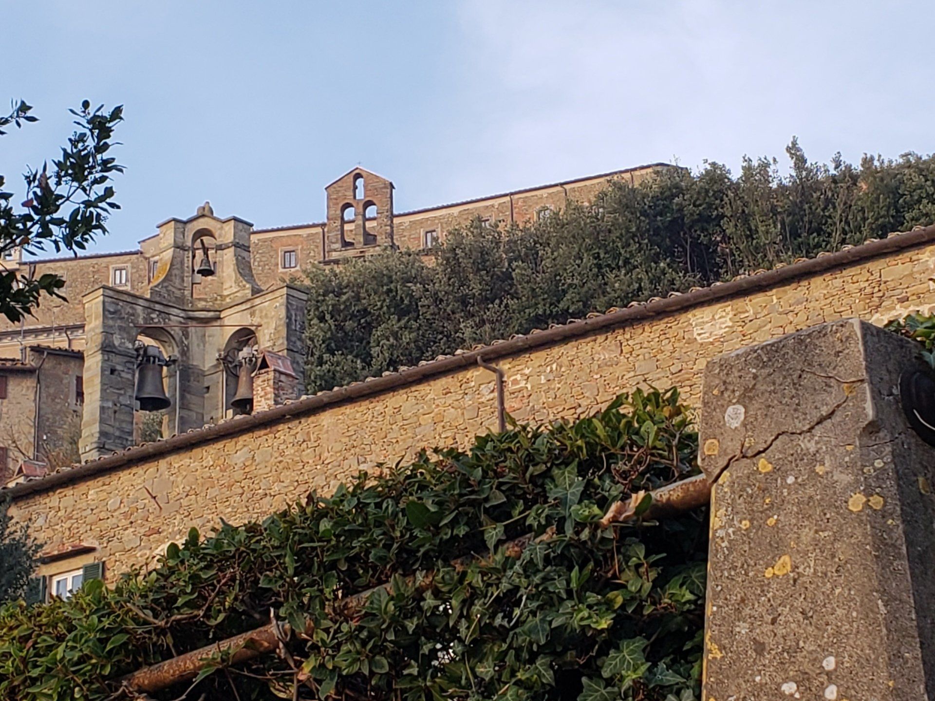 A large building with a bell tower on top of it is surrounded by trees.