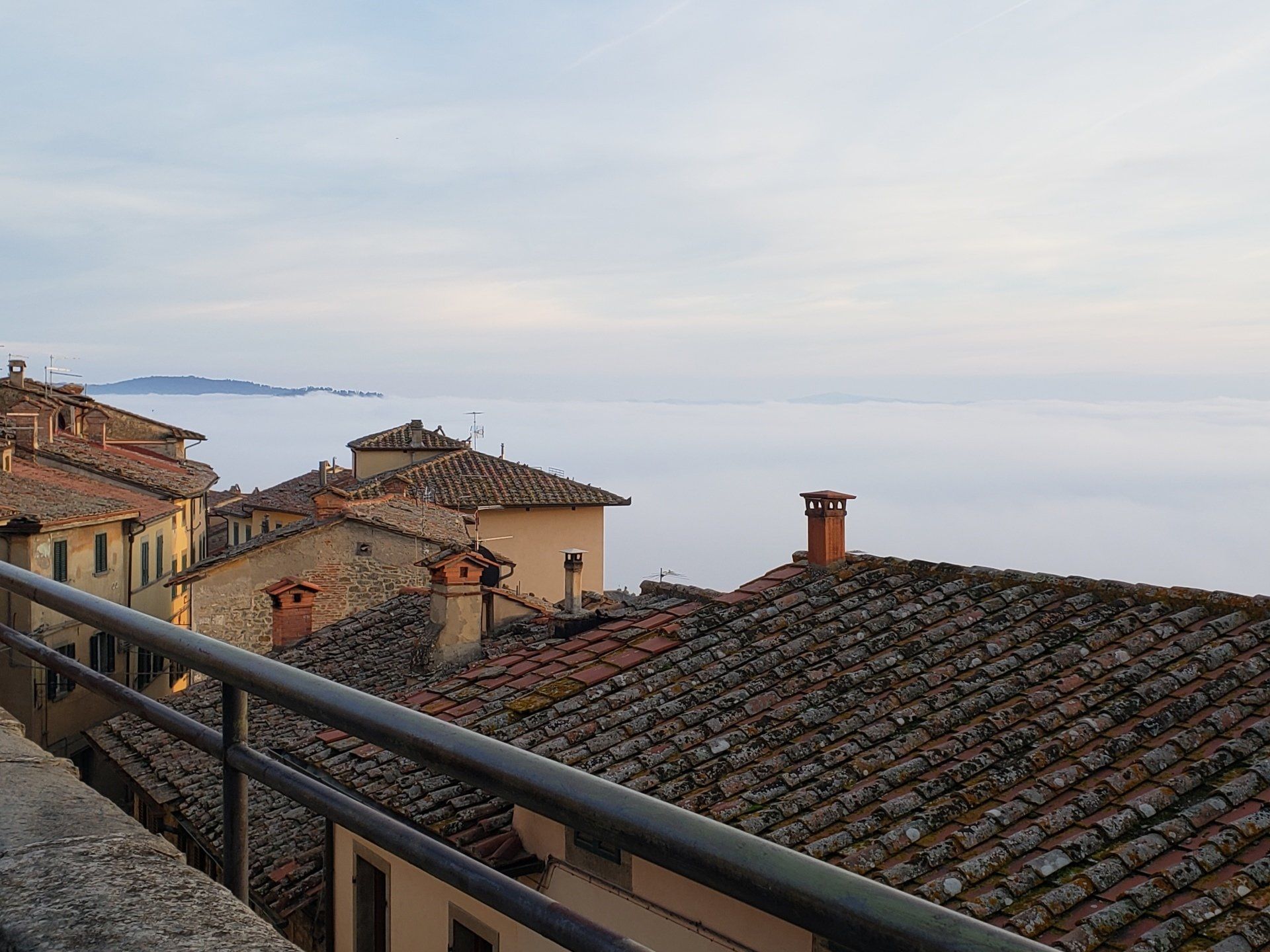 A view of a city from a balcony overlooking a body of water.