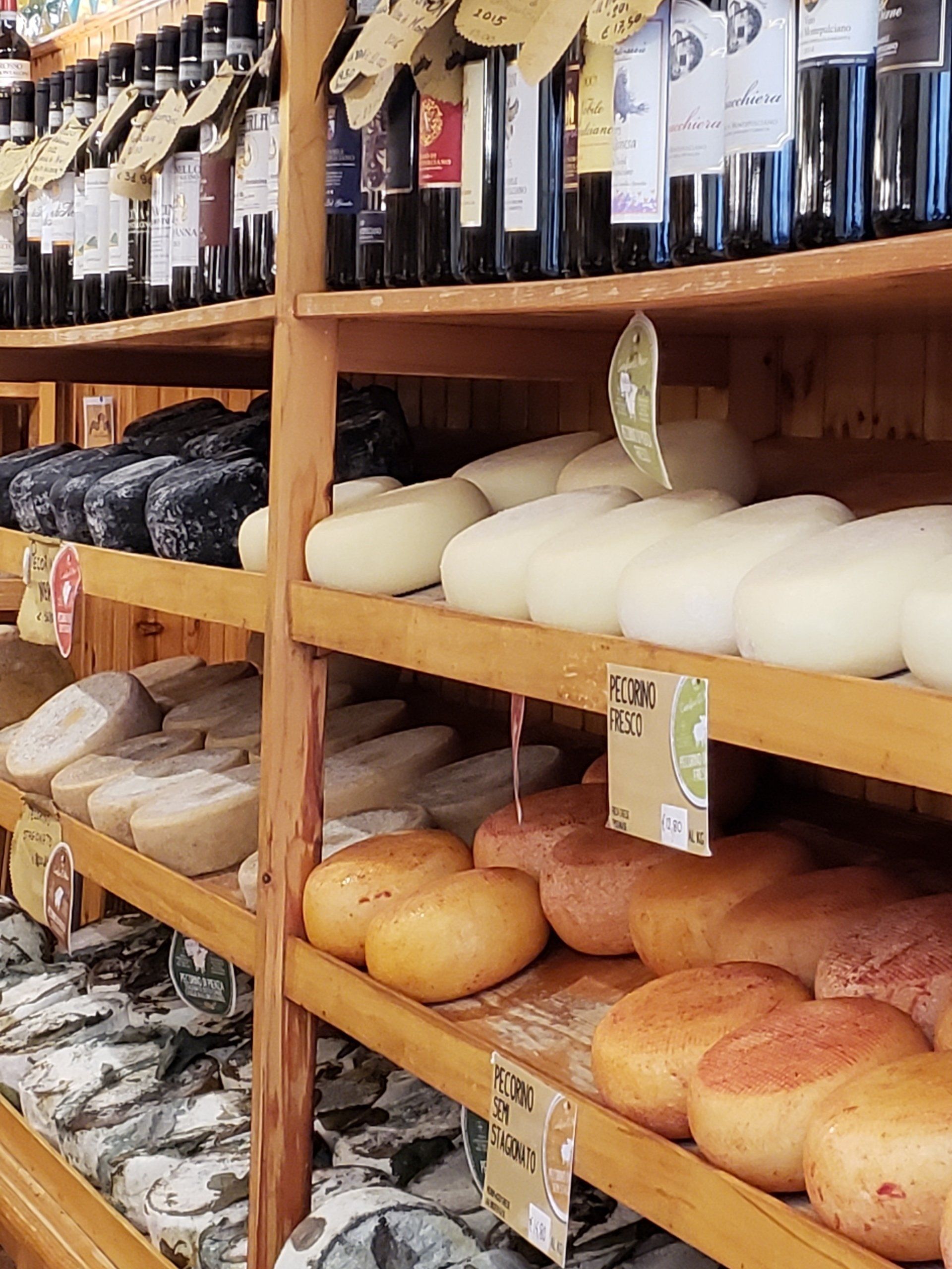 A store shelf filled with lots of different types of cheese