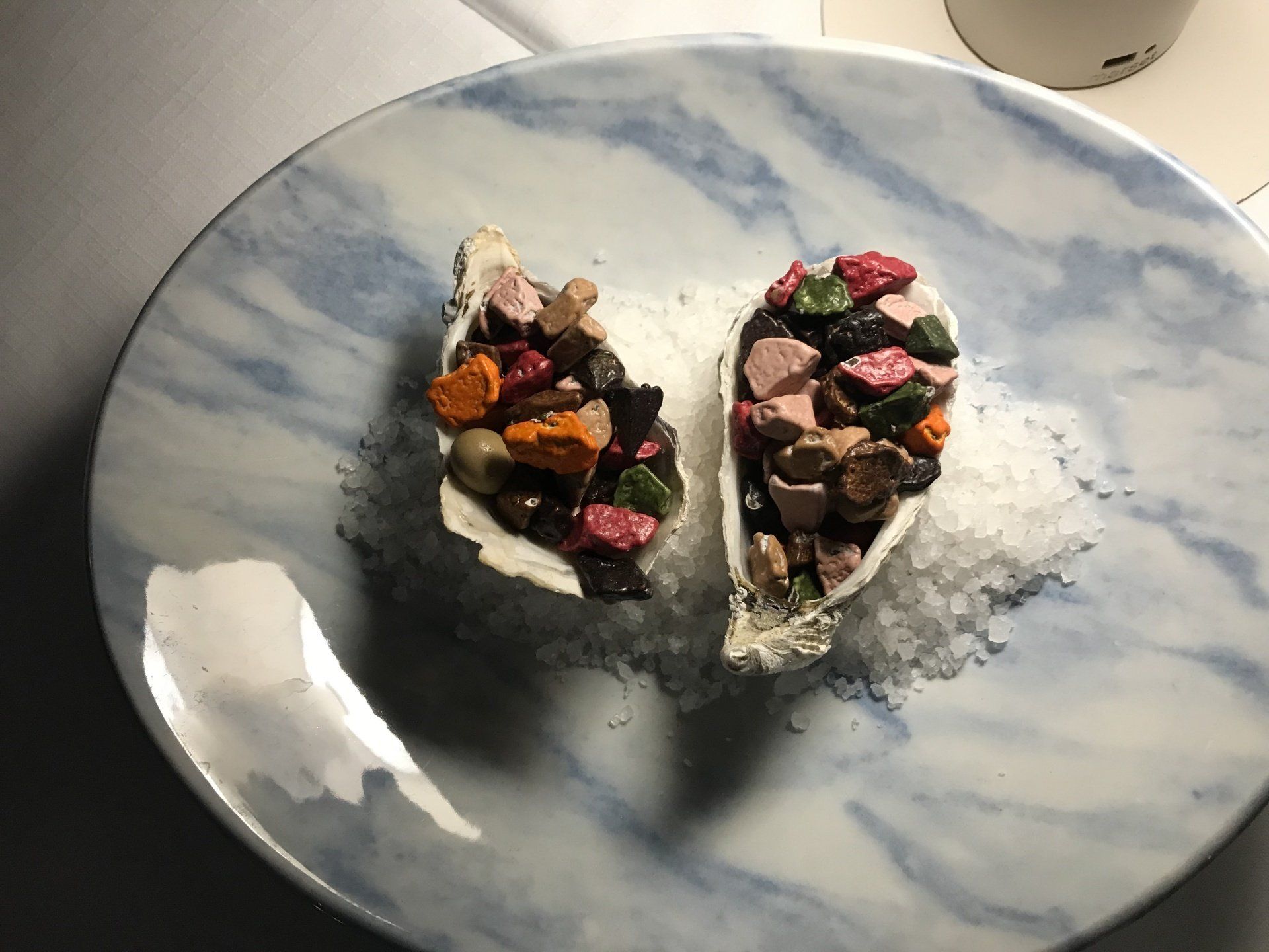 Two oyster shells filled with food are on a plate.