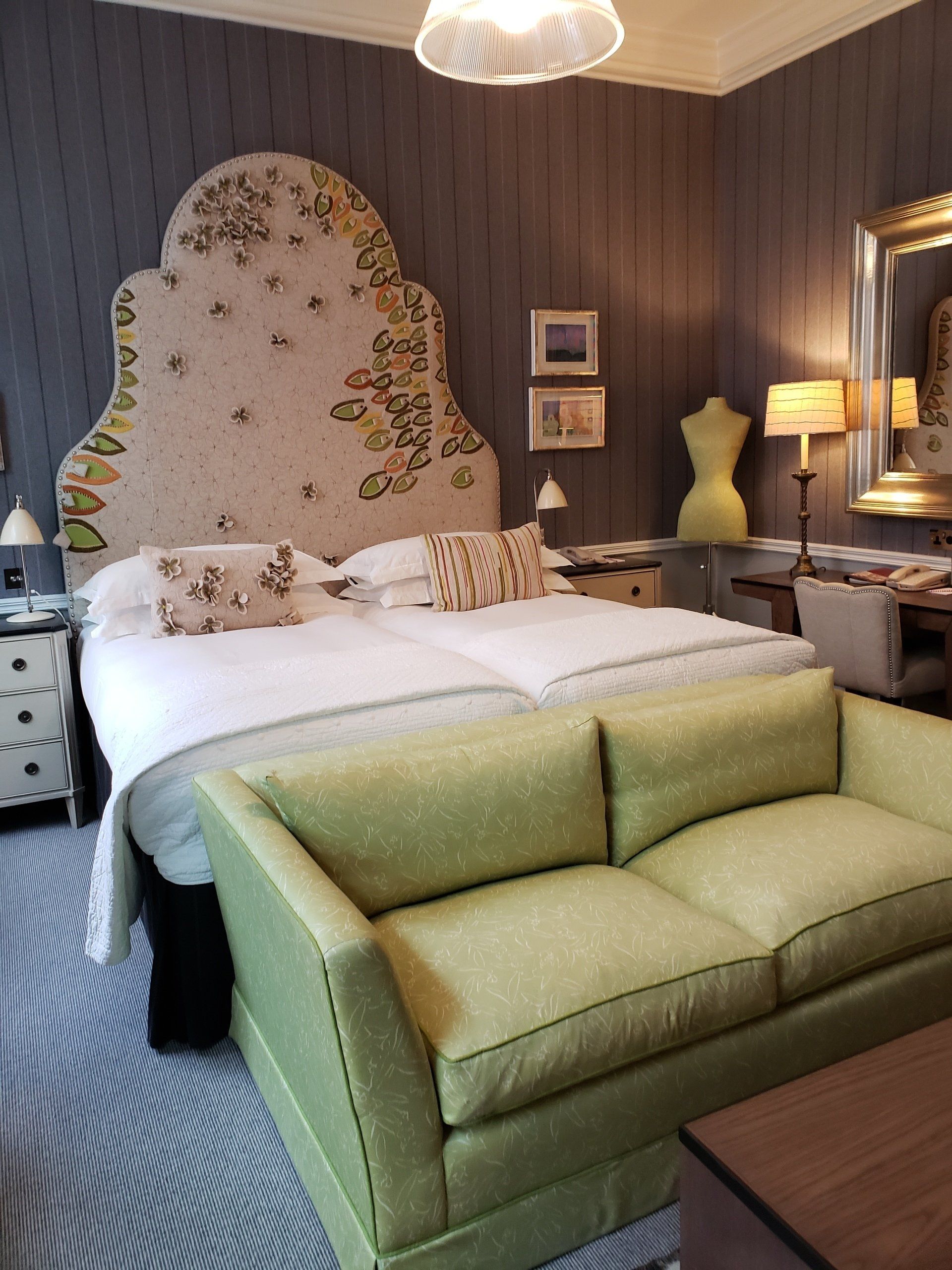 A bedroom with a large bed and a green couch