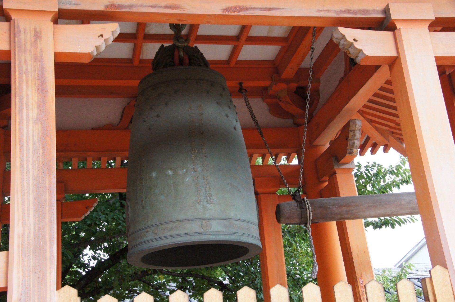 A large bell is hanging from a wooden structure