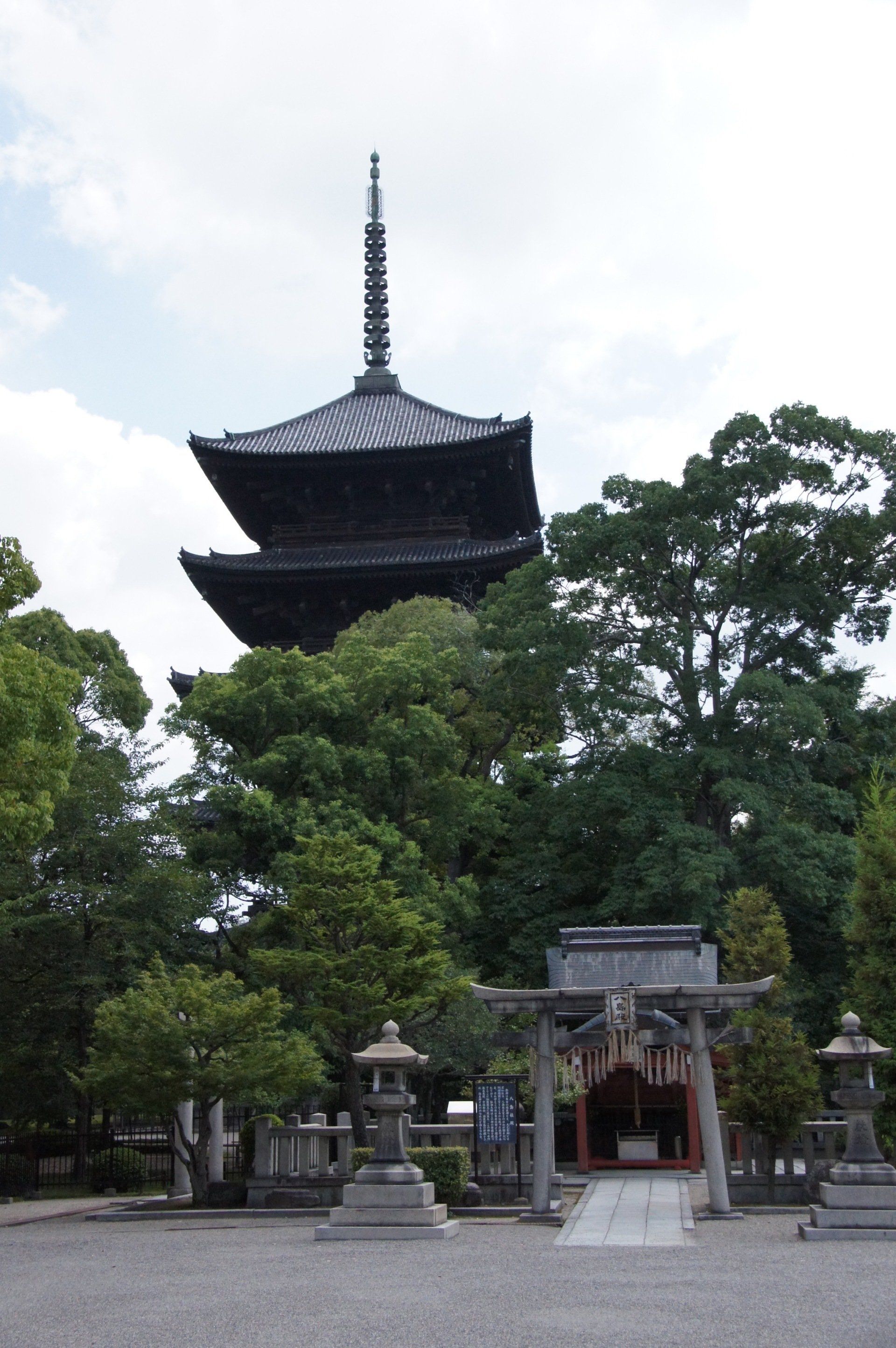 A temple with a pagoda in the background and a small shrine in the foreground.
