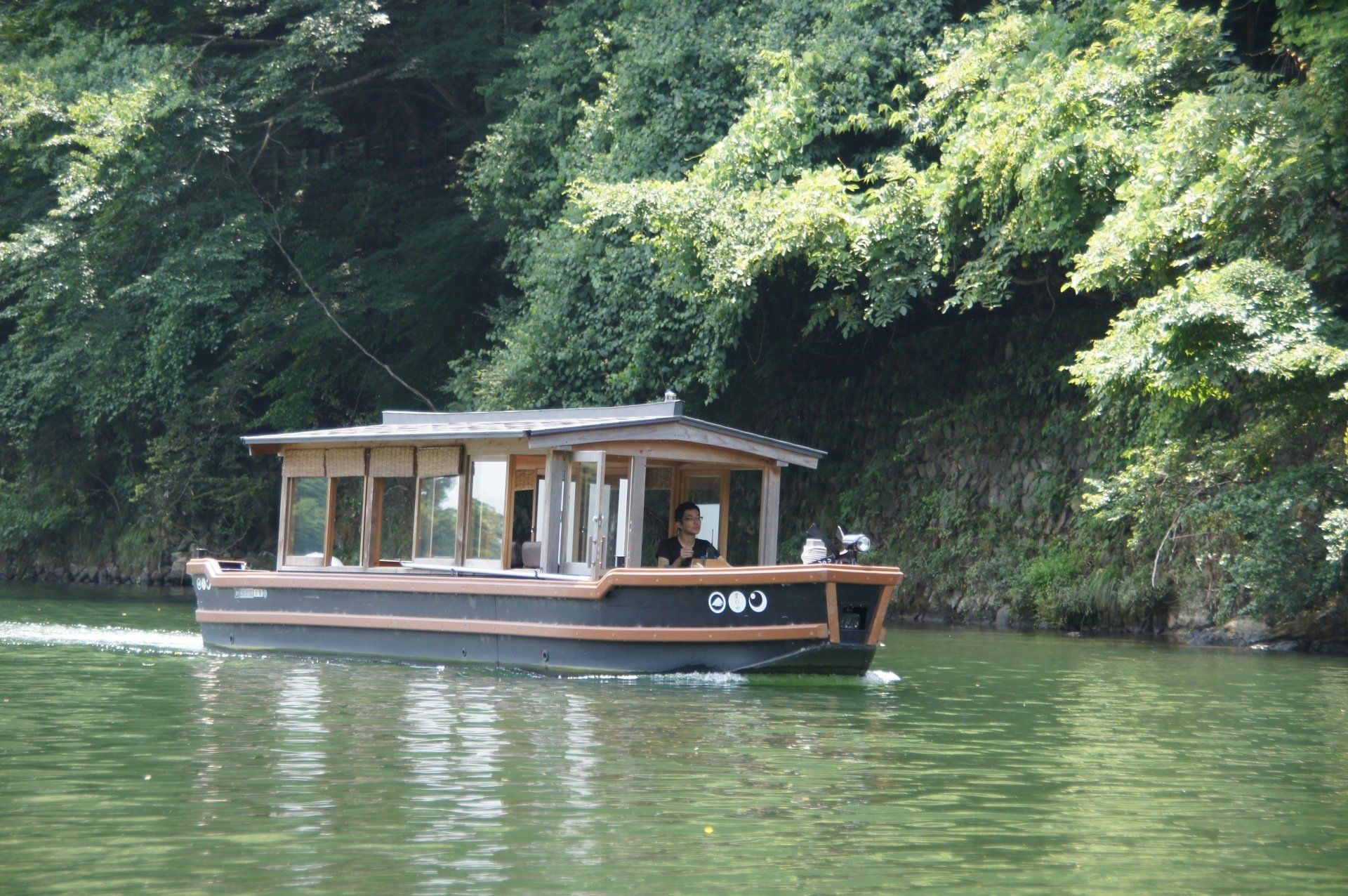 A boat is floating on a lake with trees in the background