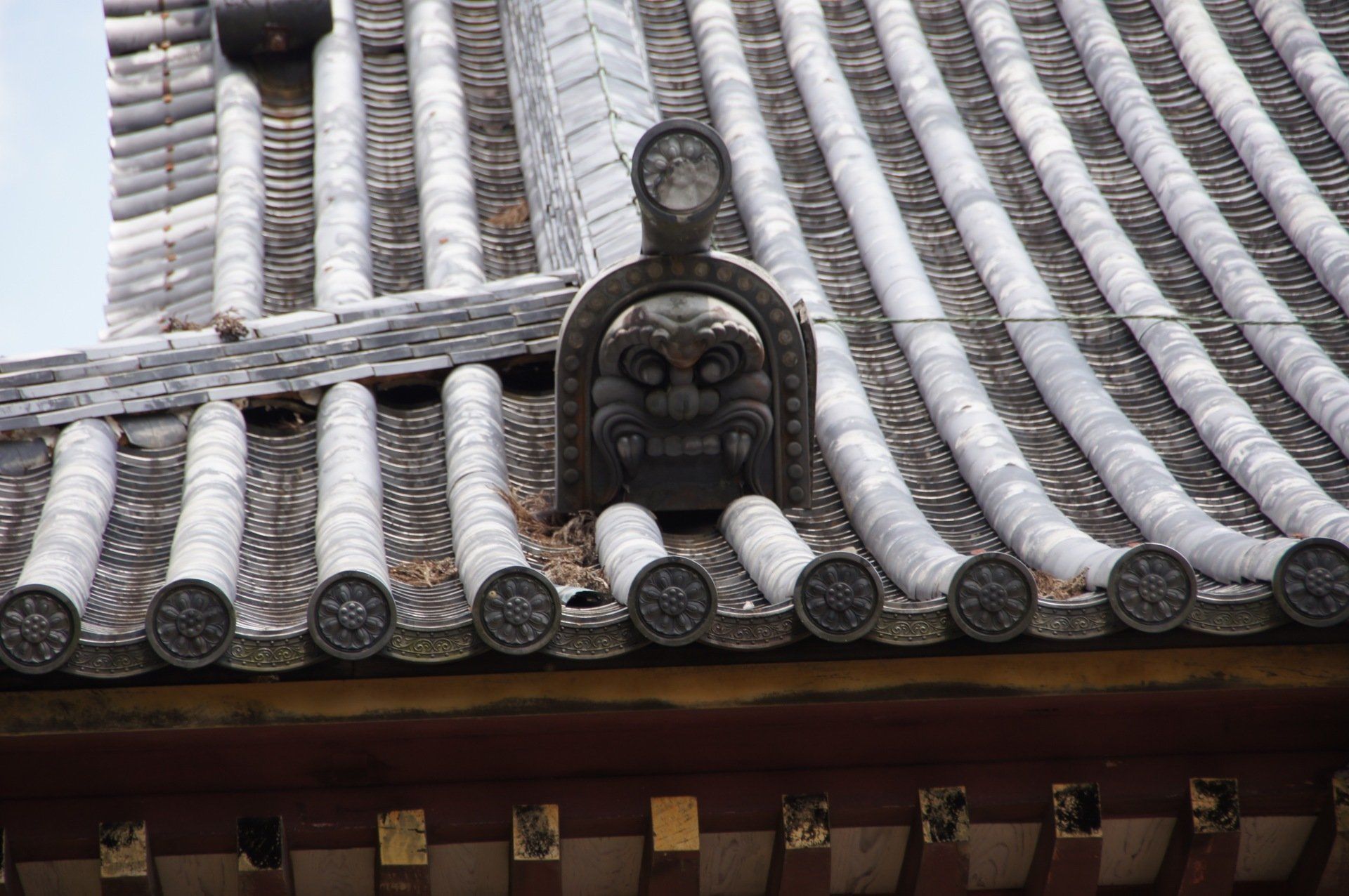 A close up of a roof with a statue on top of it.