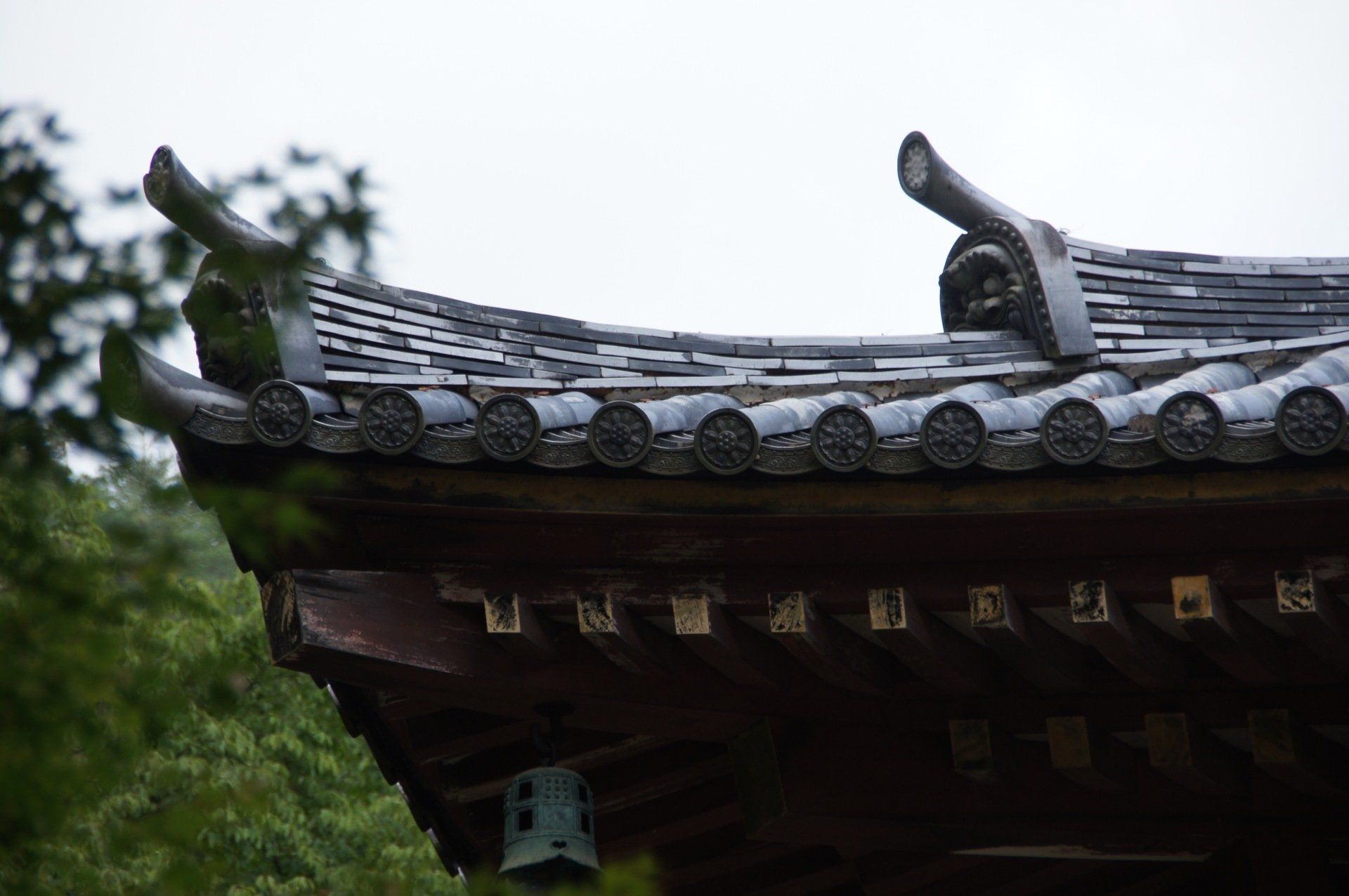 A close up of a roof of a building with a bell on it.