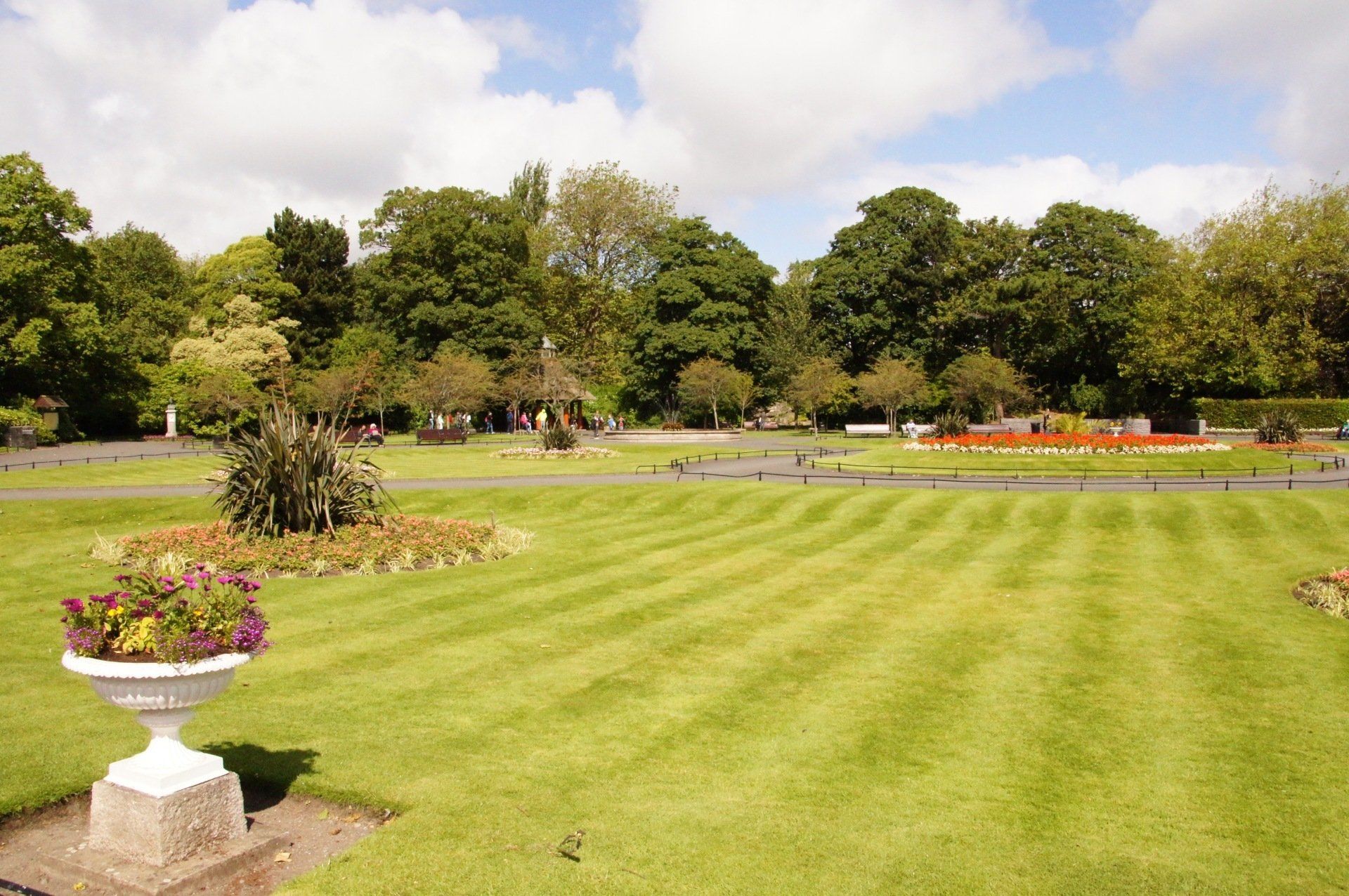 A lawn with a white urn in the middle of it