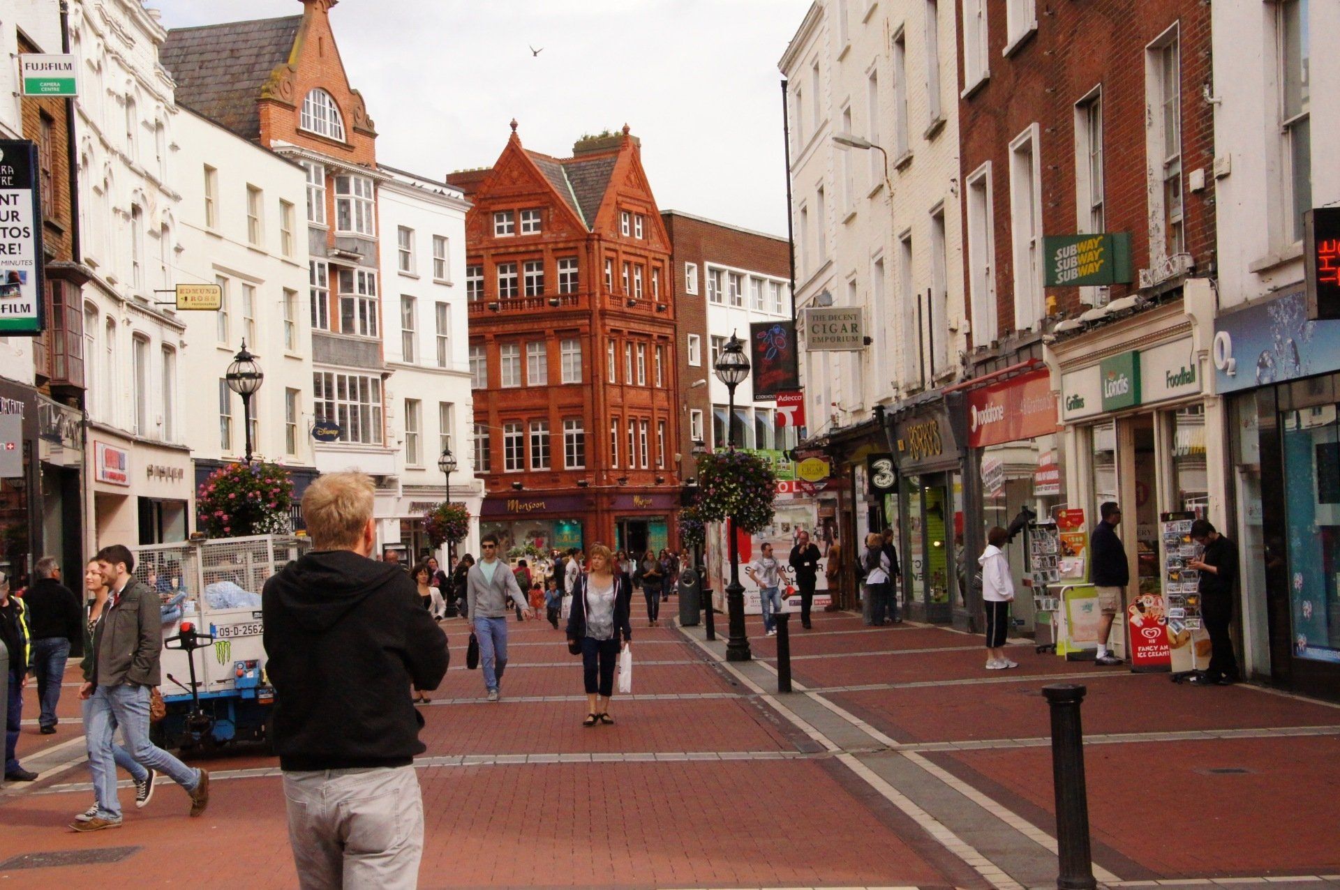 A man is taking a picture of a busy city street