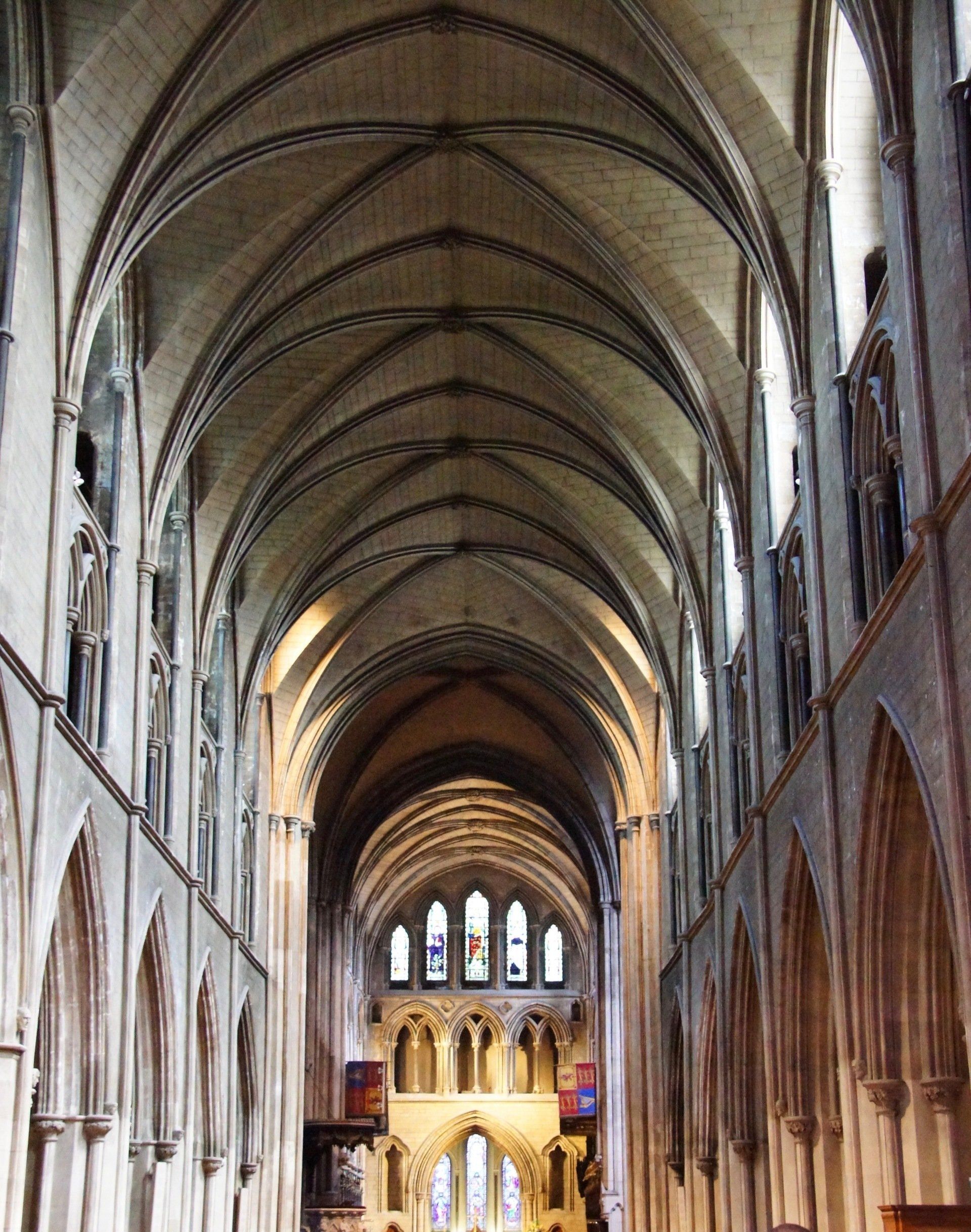 The inside of a church with arched ceilings and stained glass windows