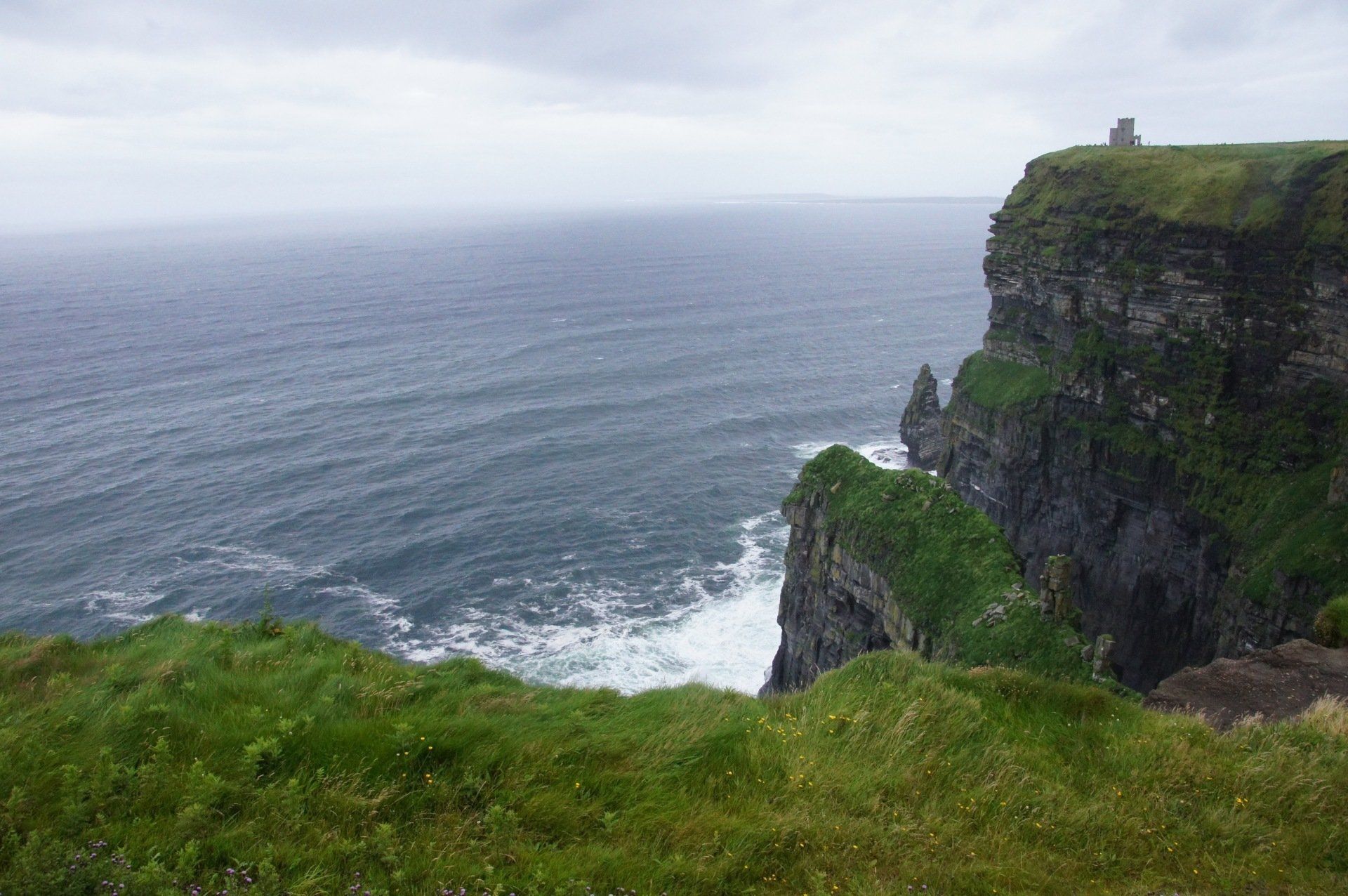 A view of the ocean from the top of a cliff.