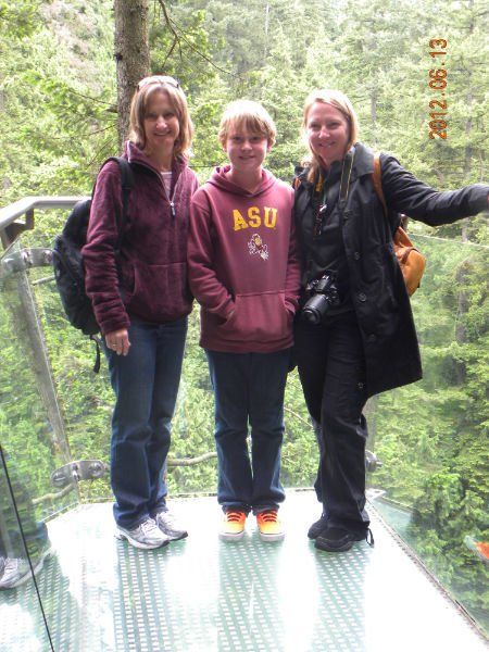 Three people posing for a picture with one wearing a sweatshirt that says asu