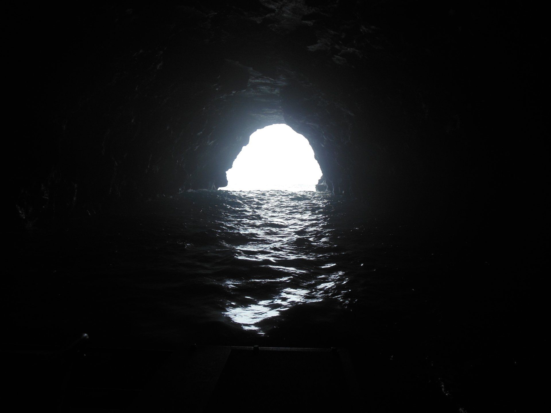 A dark cave with a light coming out of it
