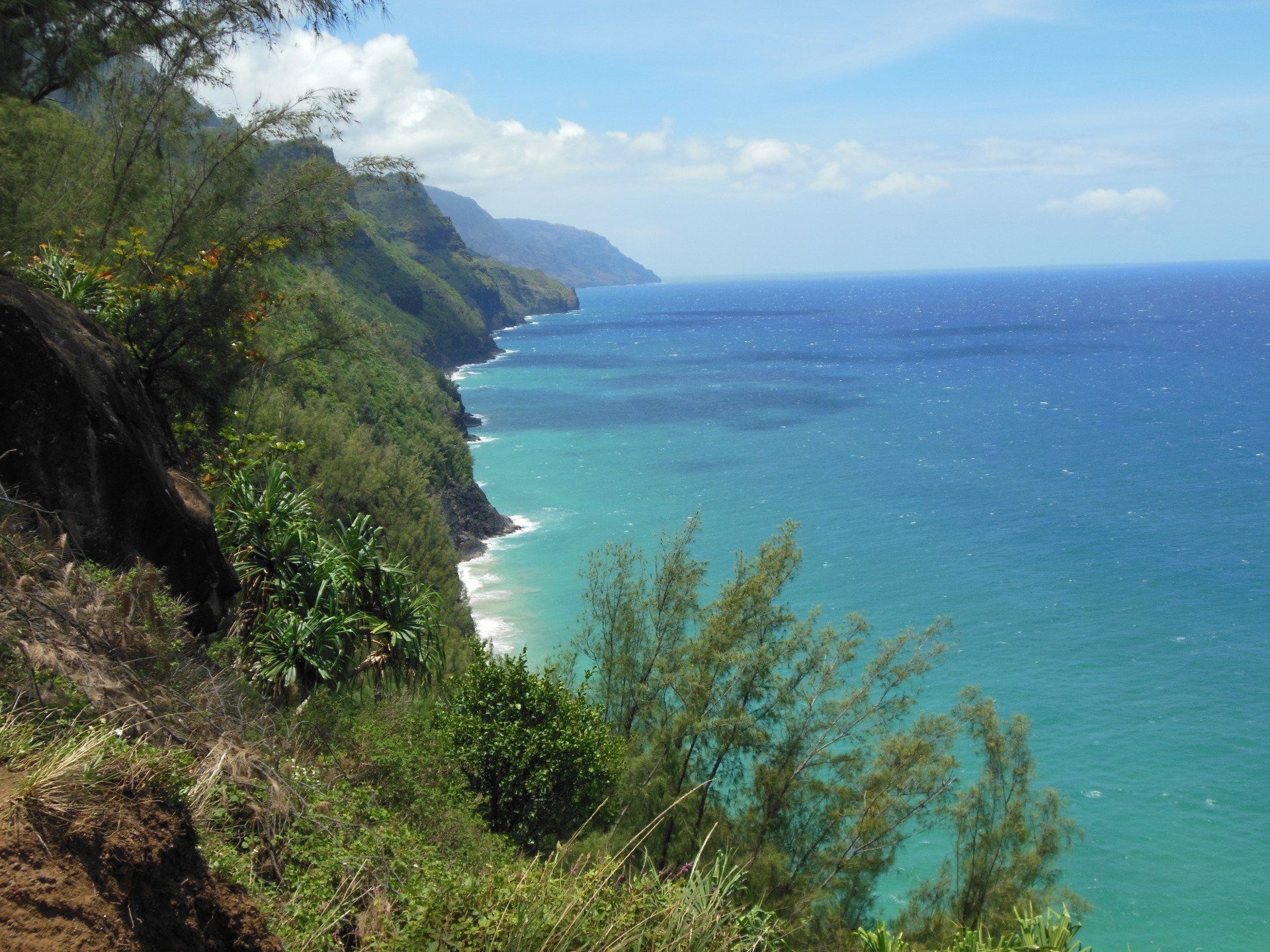 A cliff overlooking a body of water with mountains in the background